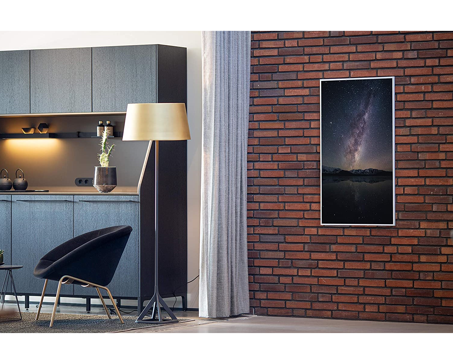 Innenaufnahme einer Küche mit Backsteinmauer, Kunstwerk und Stehleuchte.