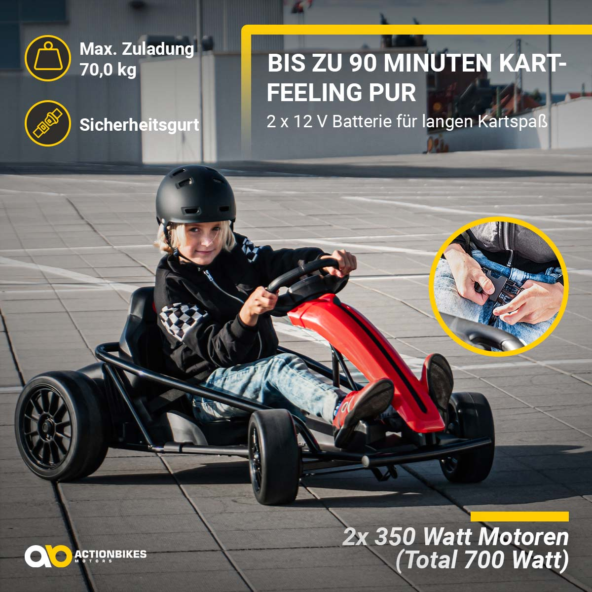 Ein Kind in einem schwarzen Helm und einer Jacke fährt ein rot-schwarzes Go-Kart auf einer gepflasterten Fläche.