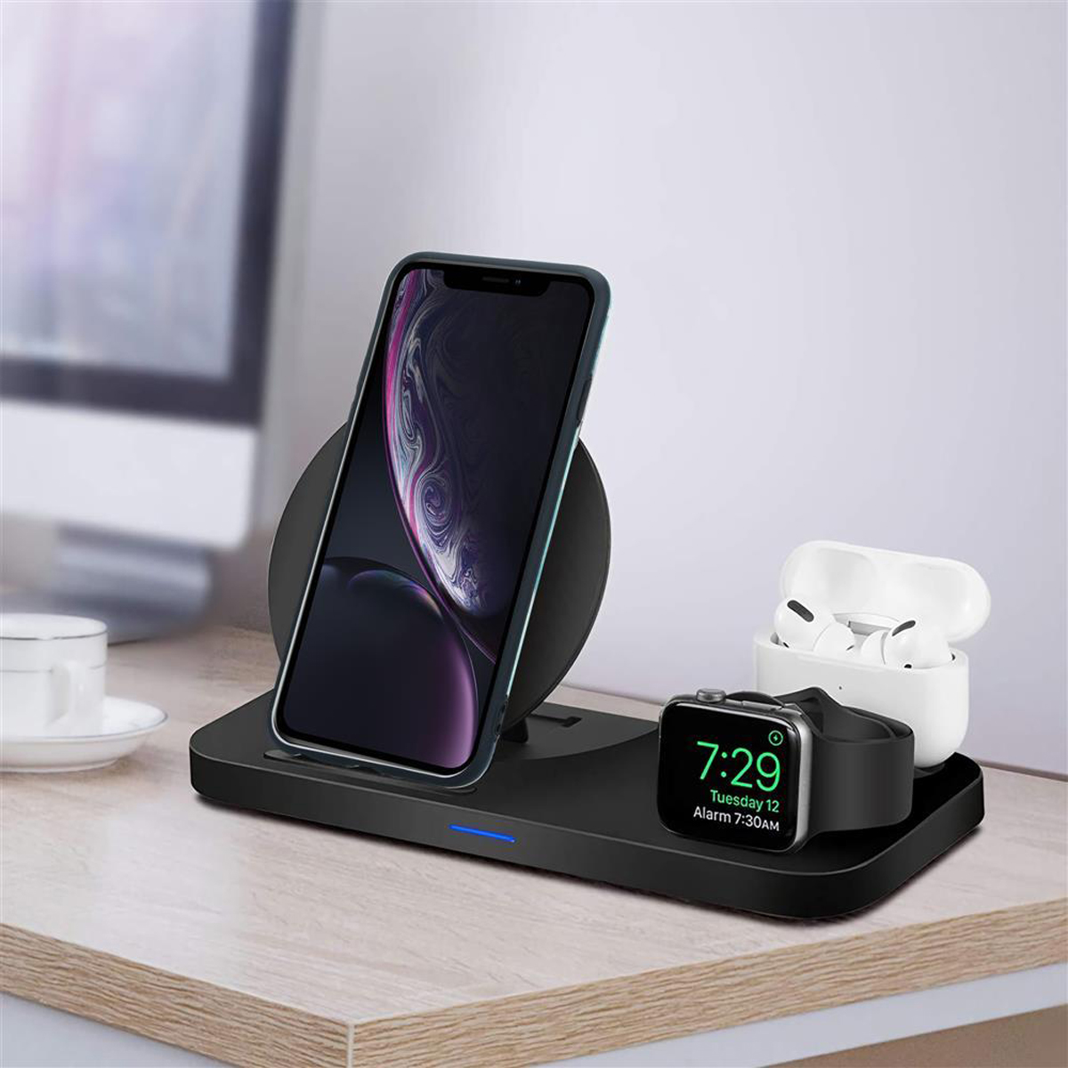 Stazione di ricarica wireless con telefono, AirPods e Apple Watch. Tutti gli oggetti sono su una scrivania.