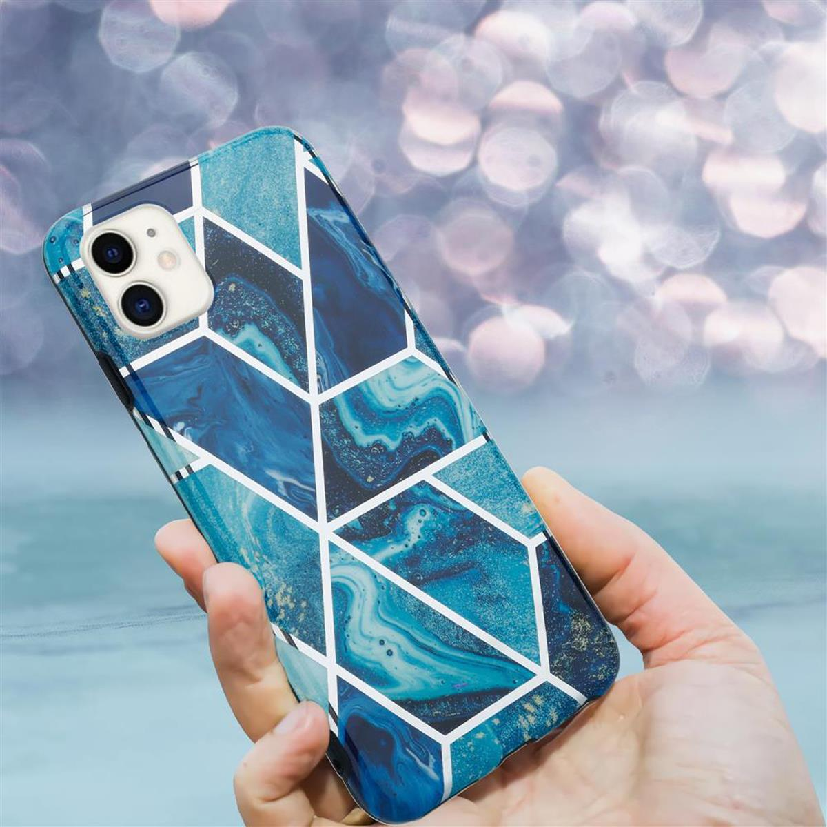 Mano che tiene un telefono con una custodia a fantasia blu. Sfondo bokeh.