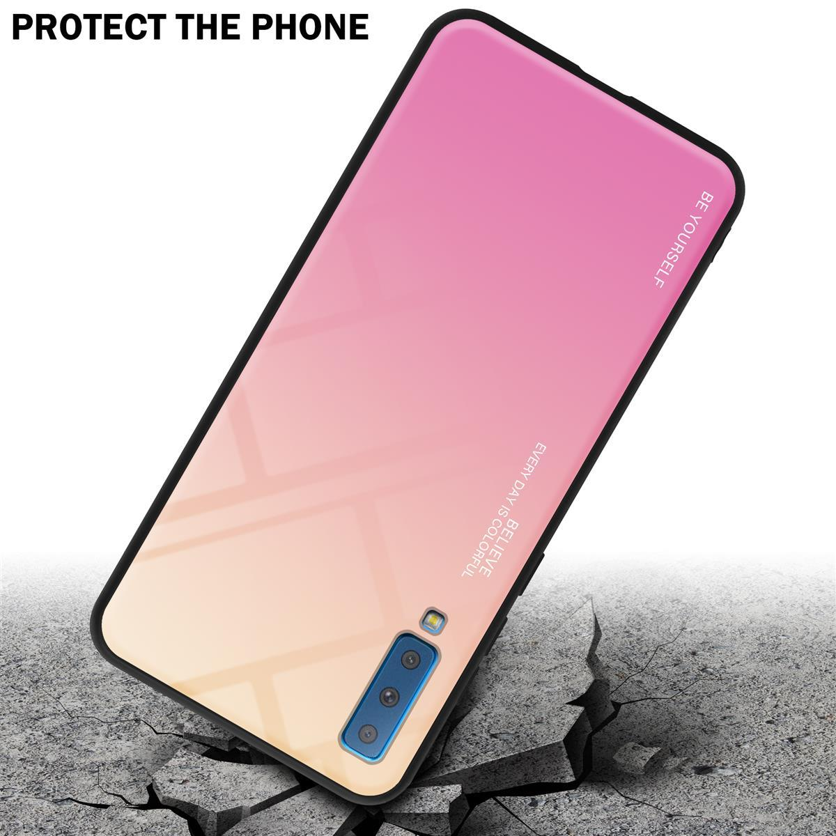 Un telefono con una custodia sfumata rosa e gialla. Il telefono è su una superficie di cemento screpolata.