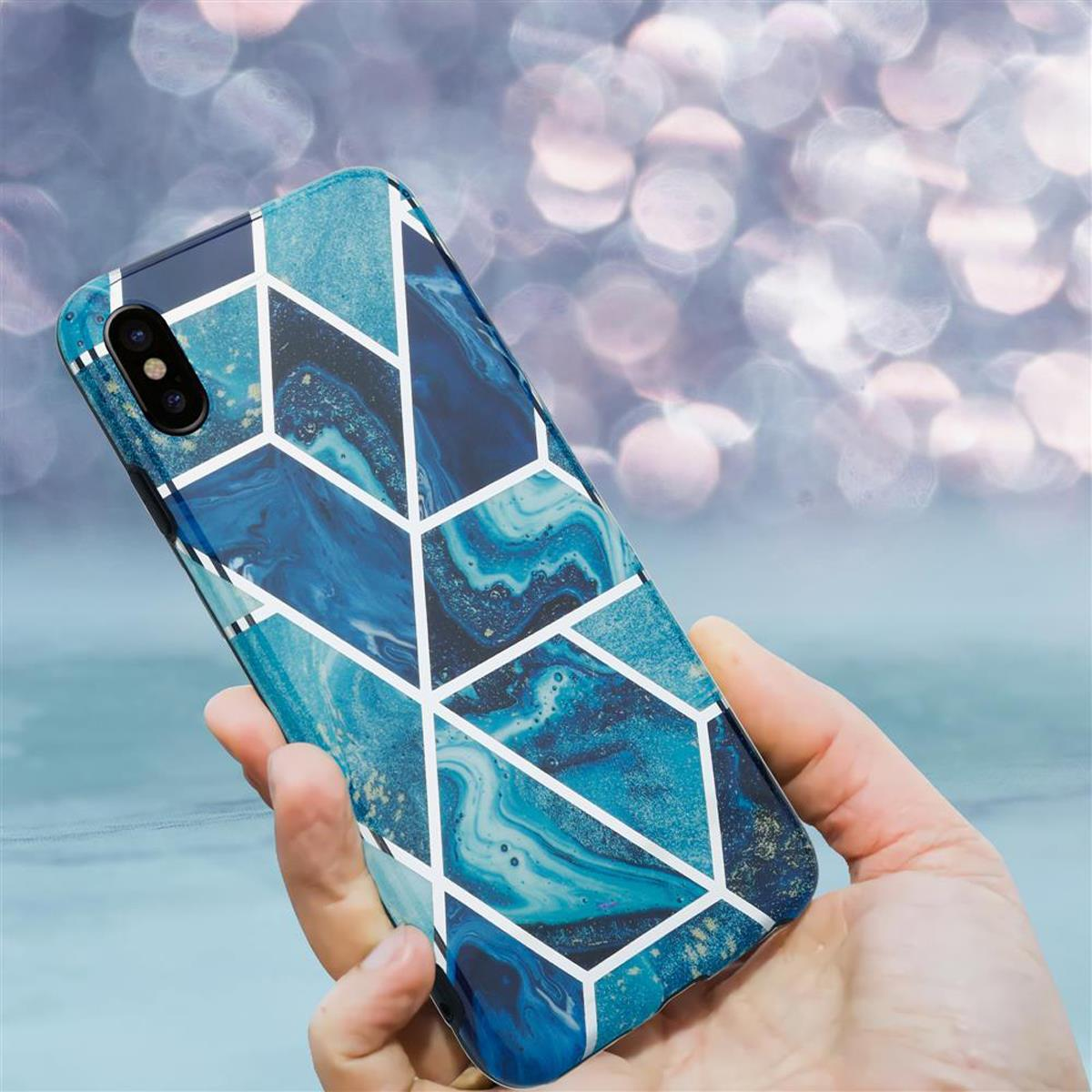 Mano che tiene un telefono con una custodia a motivi geometrici blu.