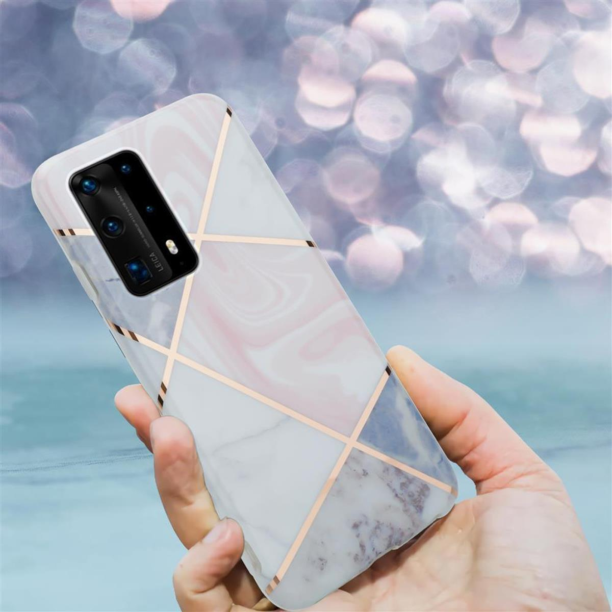 Mano che tiene un telefono con custodia in marmo e design geometrico dorato.