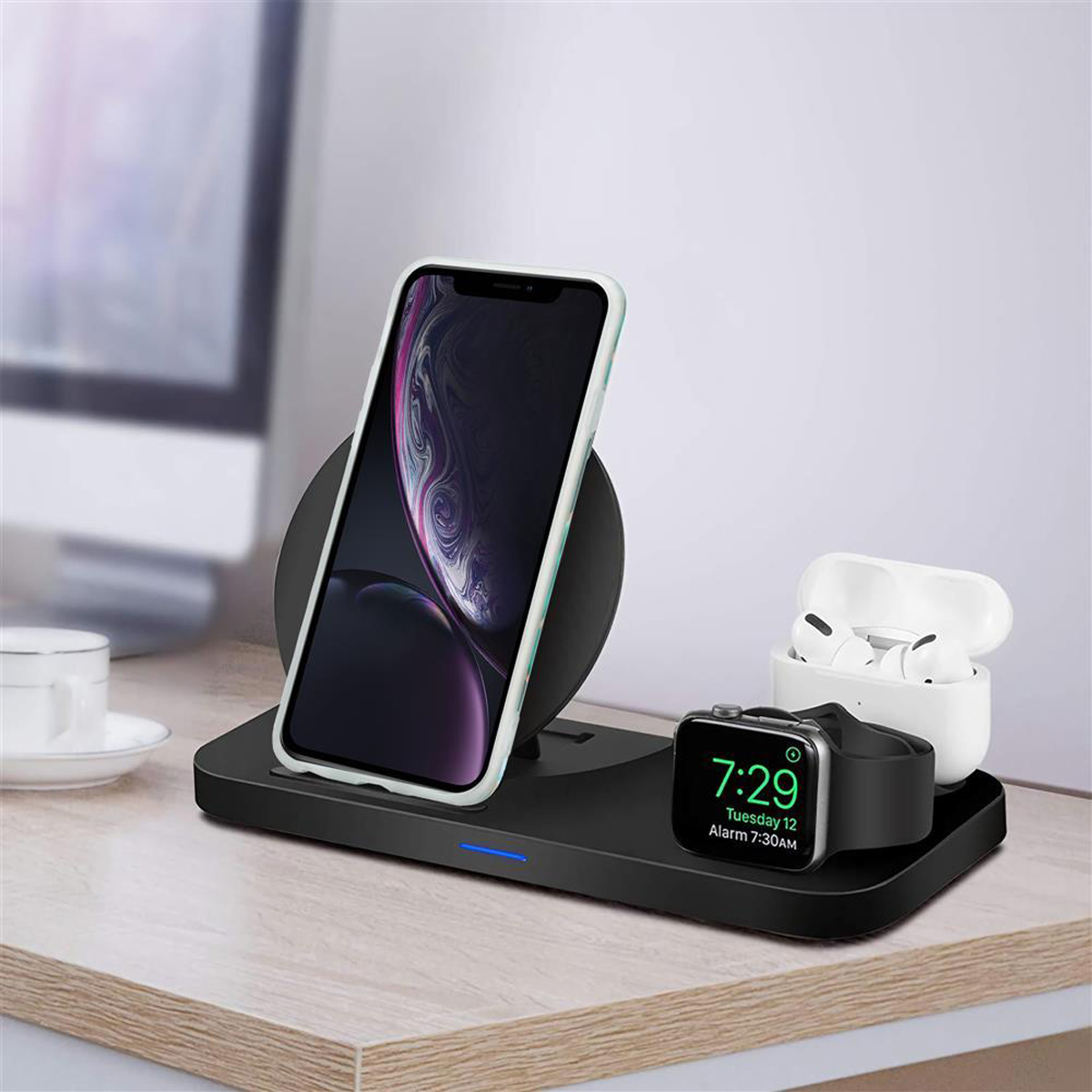 Un'installazione da scrivania con un telefono, un caricatore wireless, auricolari e uno smartwatch.