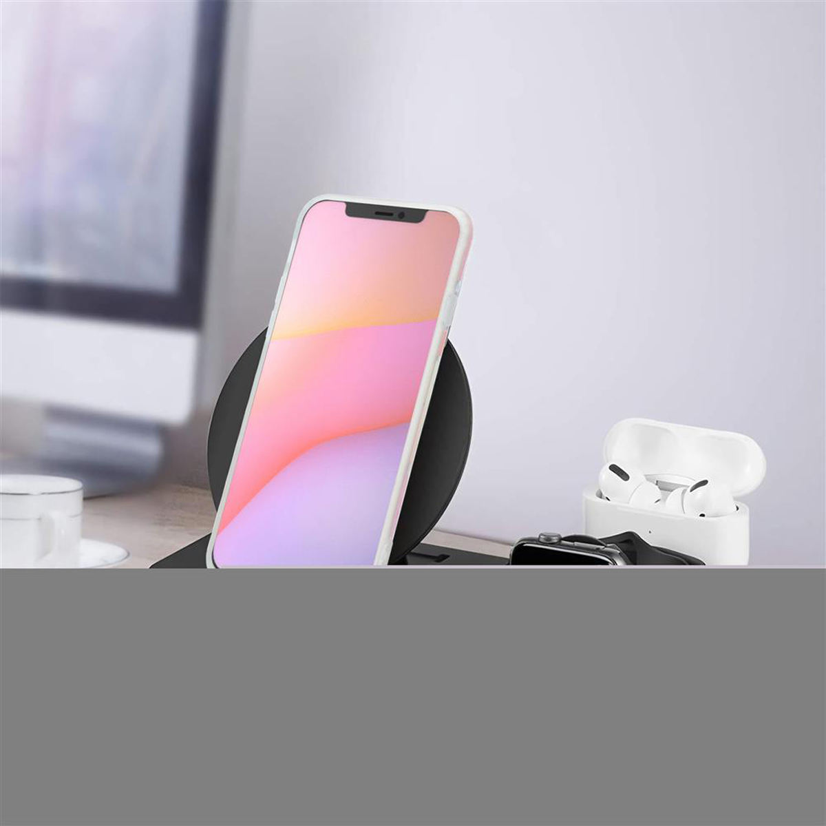 Telefono su caricatore wireless. AirPods e smartwatch su superficie bianca.