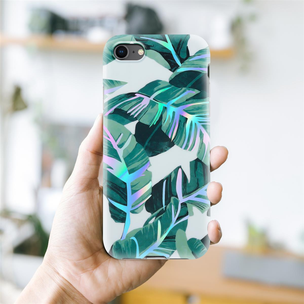 Una mano che tiene un telefono con una custodia bianca ricoperta di foglie verdi con riflessi iridescenti.
