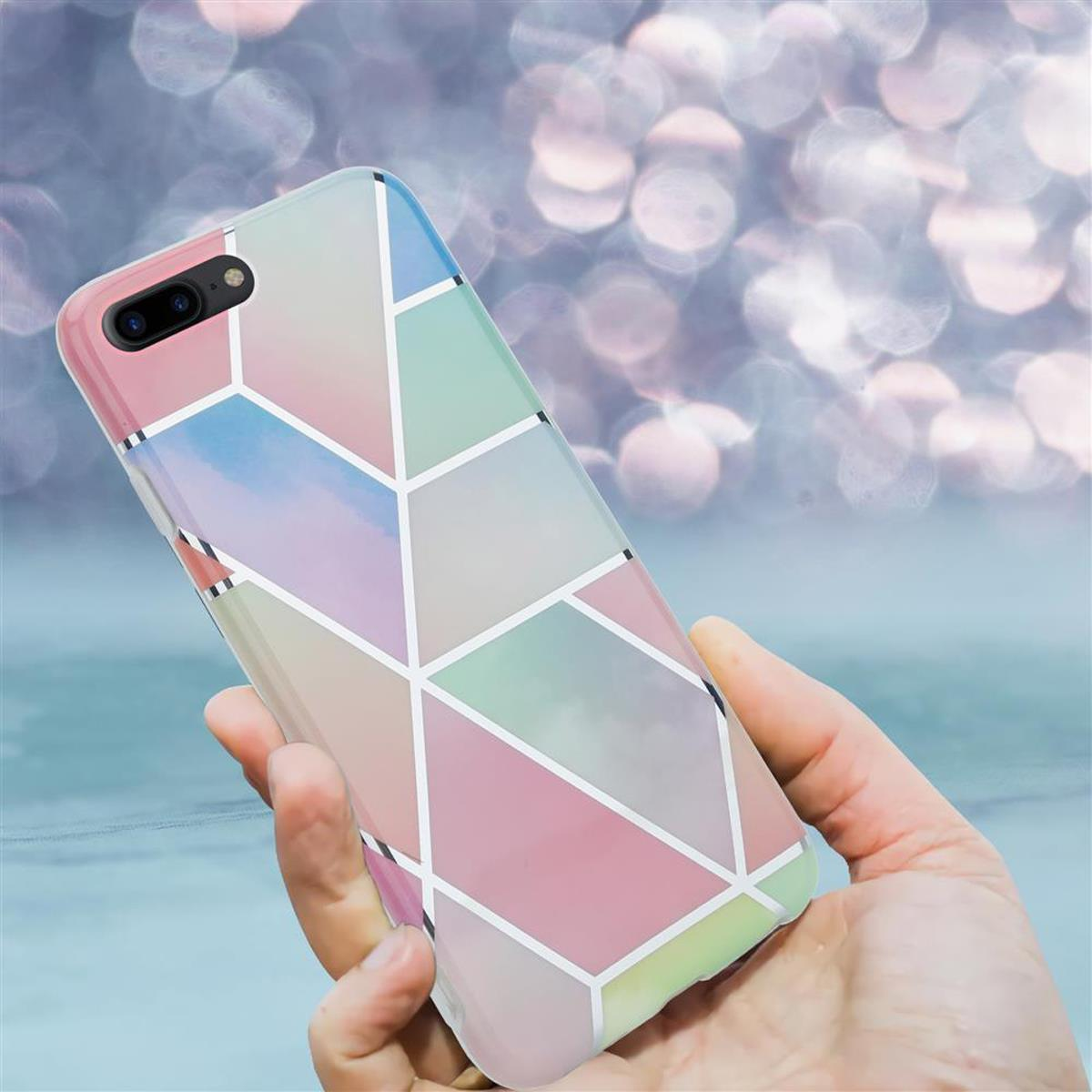 Hand hält eine Handyhülle mit geometrischem Design in Pastellfarben. Der Hintergrund ist unscharf.