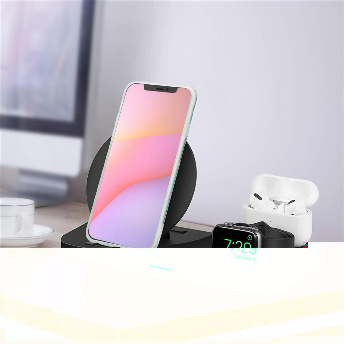 Uno smartphone, un caricabatterie wireless, auricolari e smartwatch sono su una scrivania. I colori sono nero, bianco e rosa.