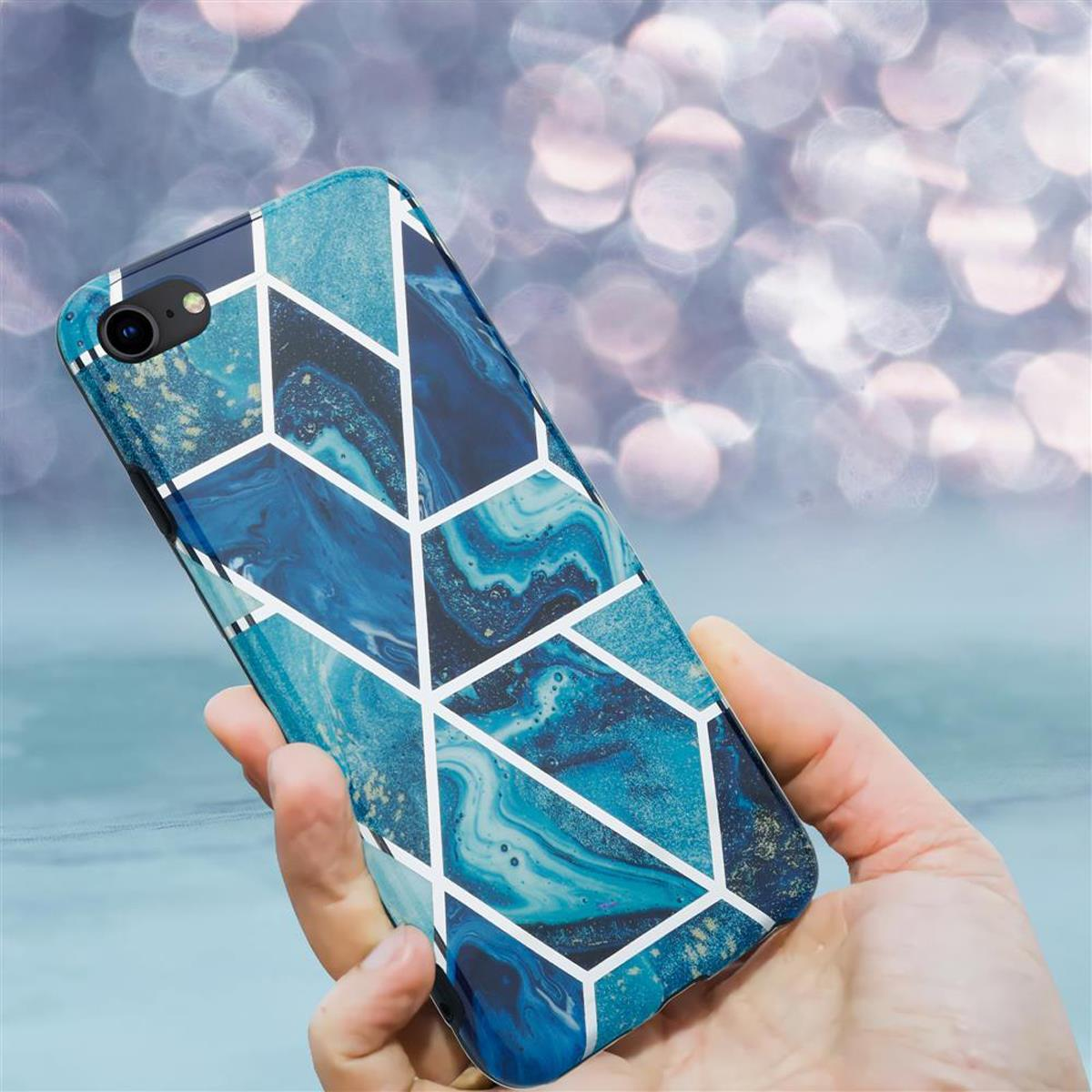 Una custodia per telefono con un design marmorizzato blu e bianco, tenuta in mano.