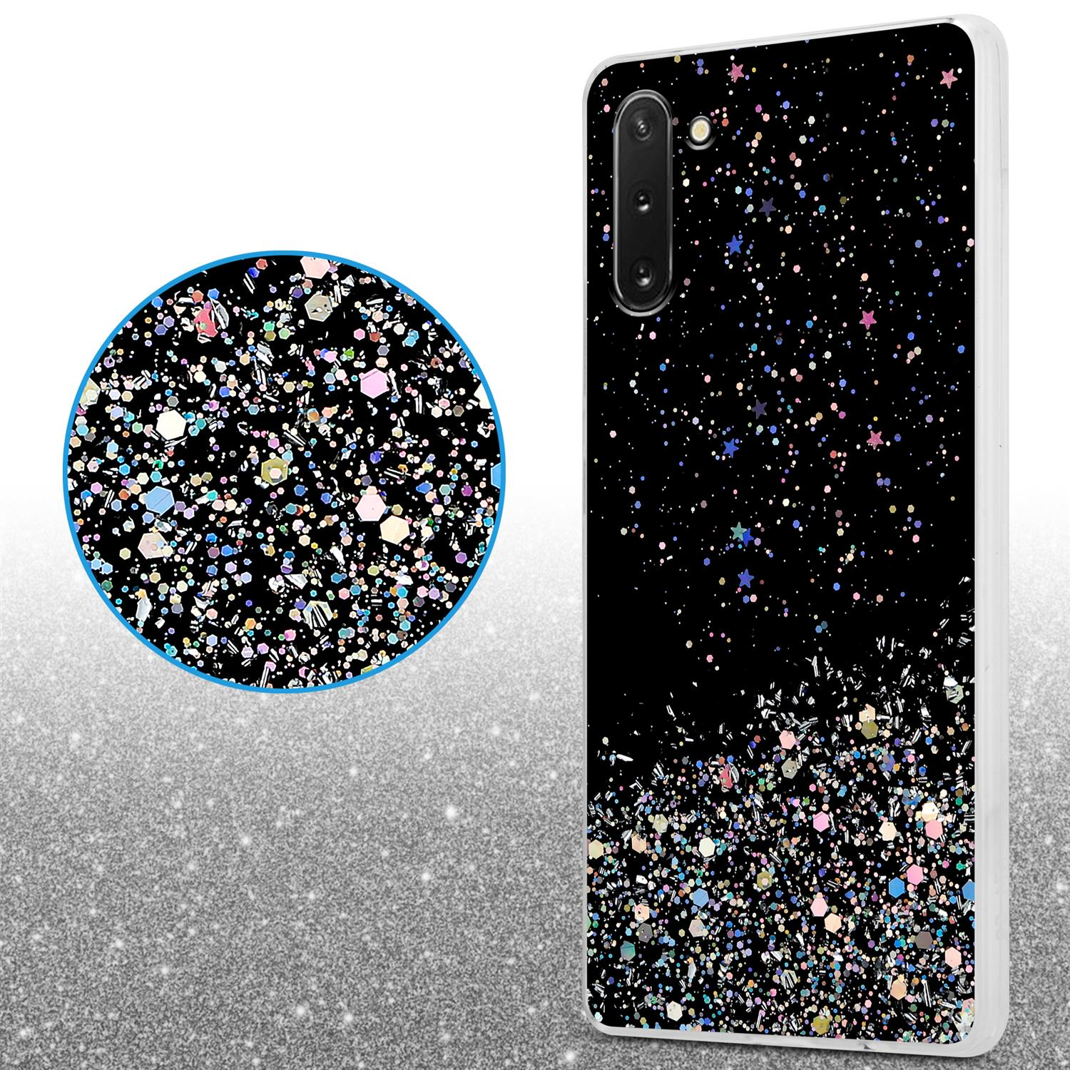 Custodia per telefono nera con design glitterato. Cerchio con lo stesso design. Sfondo glitterato argento.
