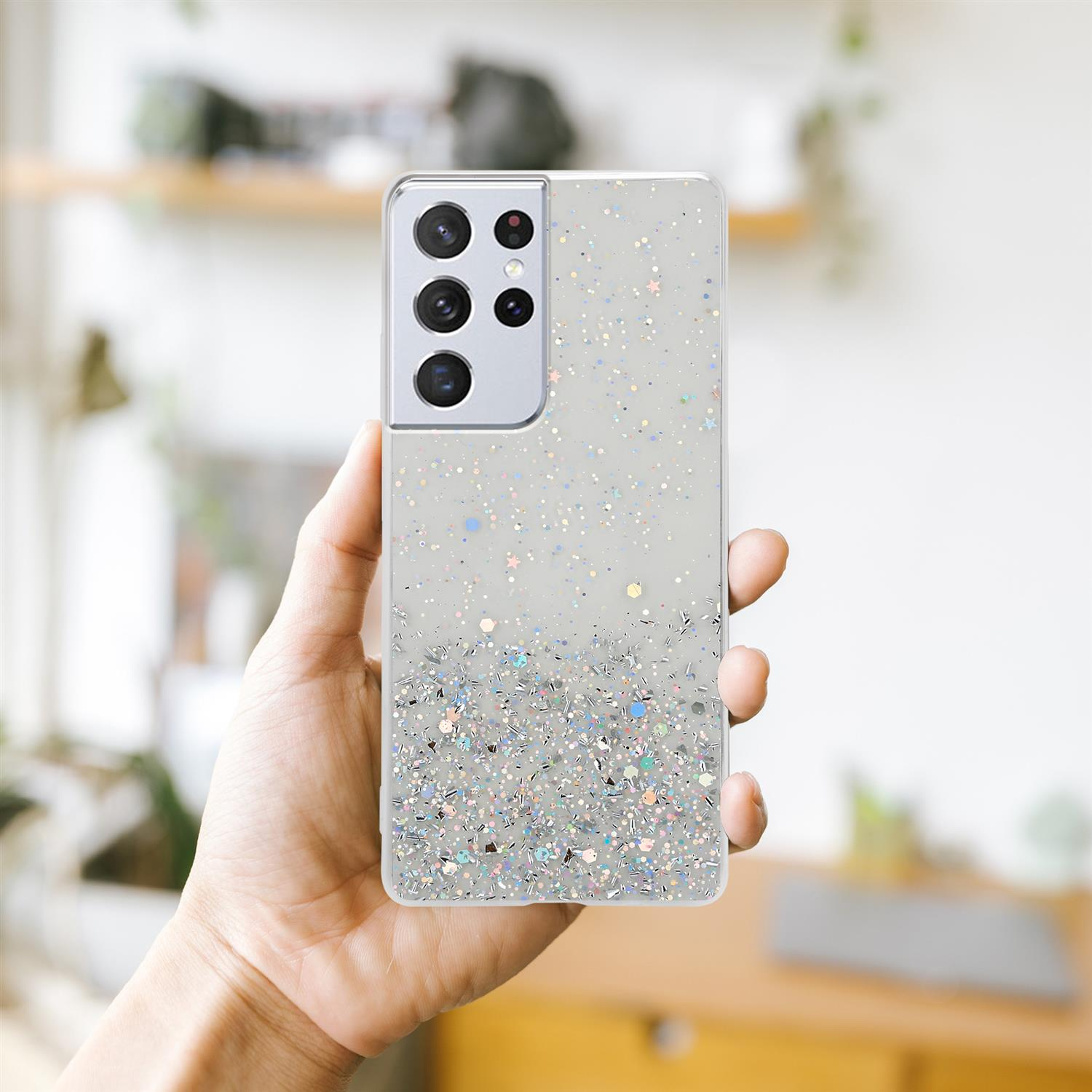 Ein Telefon in der Hand, mit einer Hülle voller Glitzer.