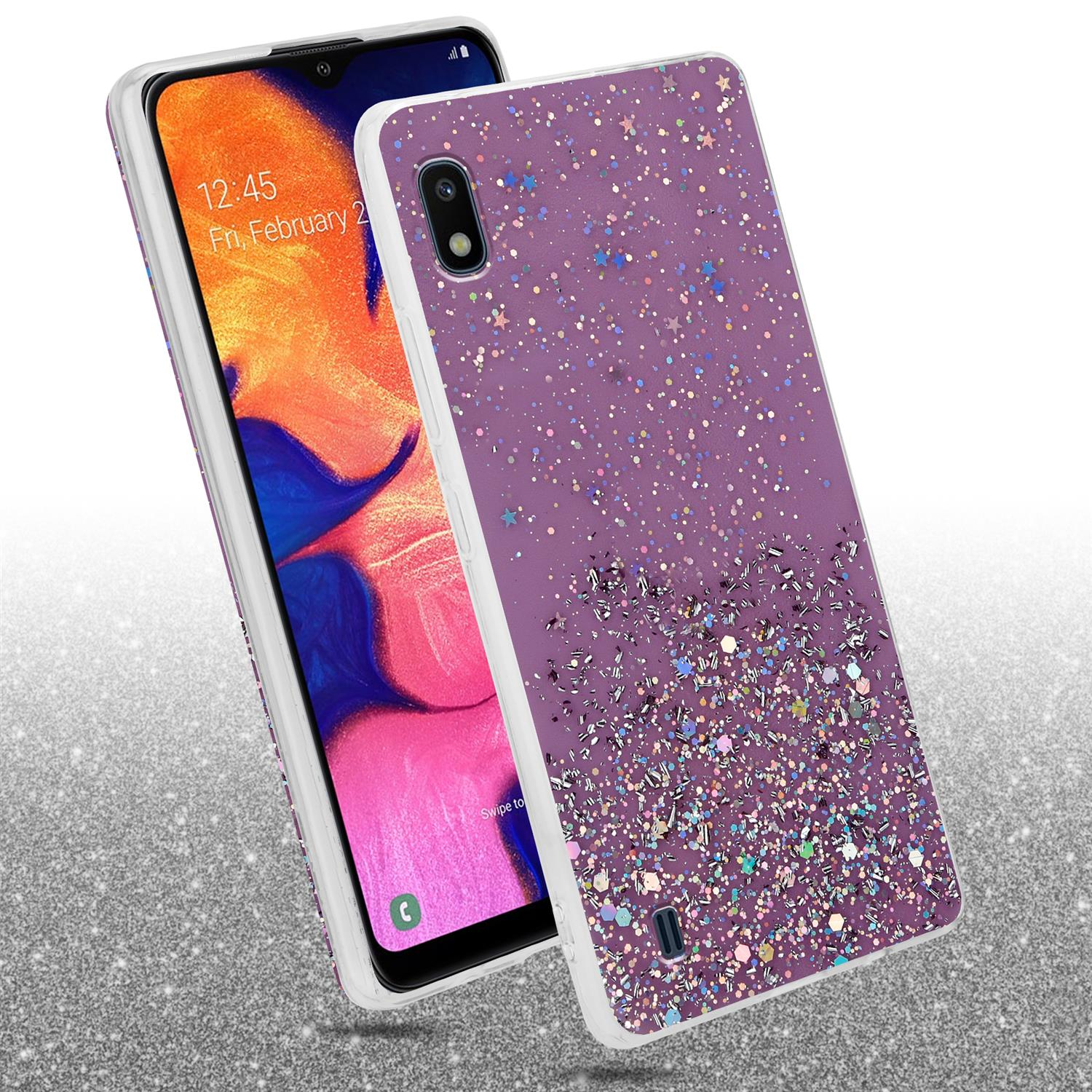 Ein Telefon mit einer lila Glitzerhülle, die Hülle ist geneigt. Das Telefon befindet sich auf einer silbernen Glitzeroberfläche.