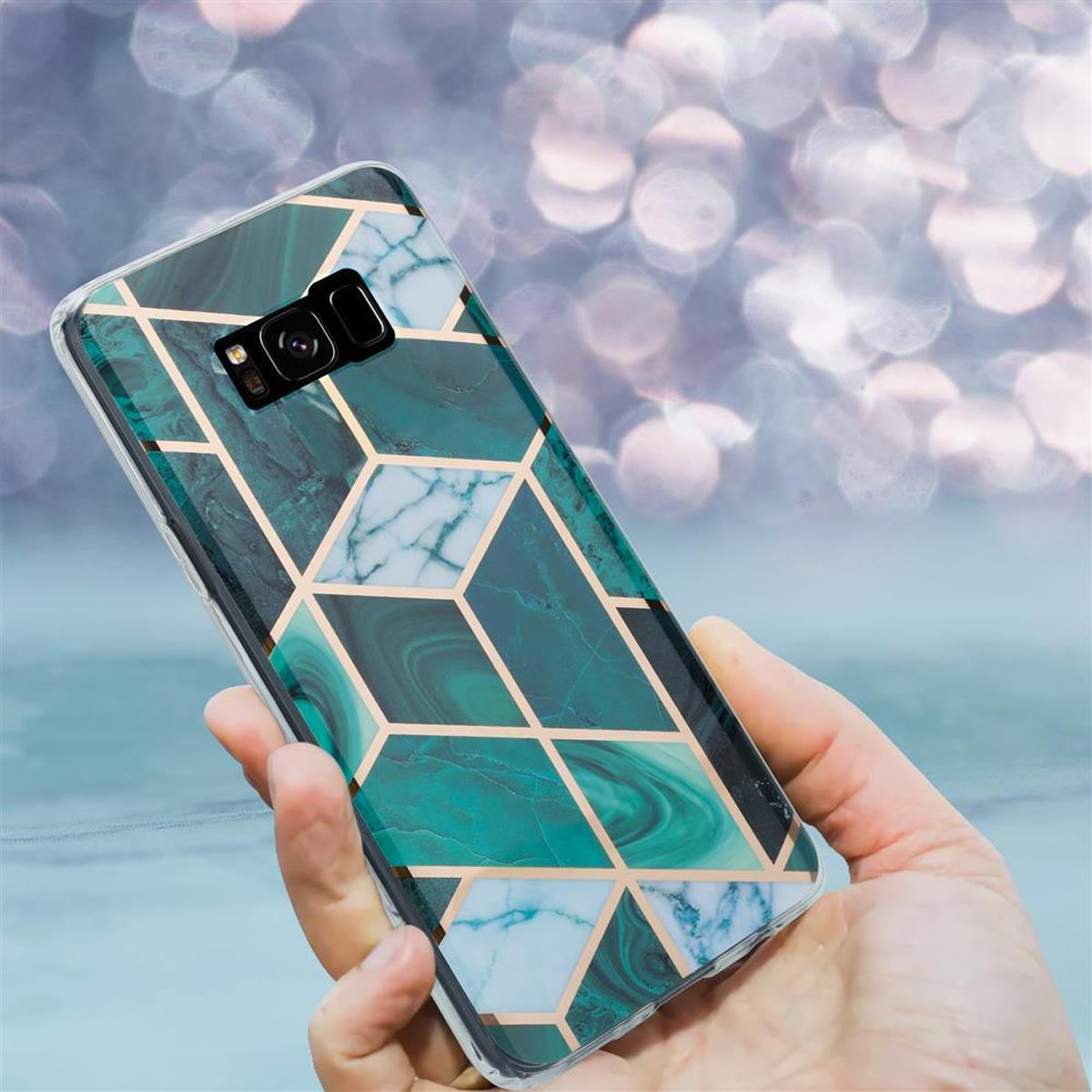 Una mano che tiene un telefono in una custodia con un design geometrico in marmo verde.