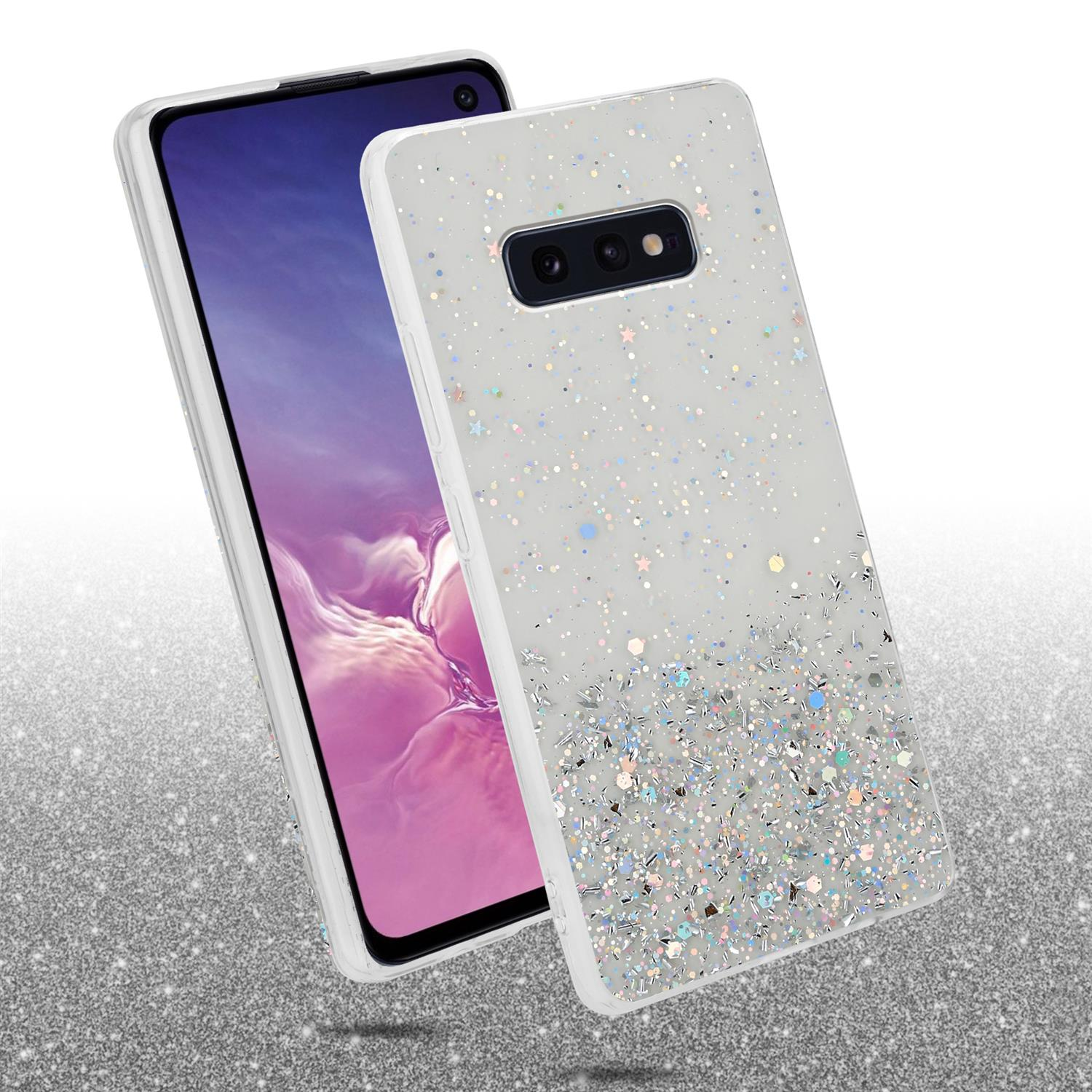 Un telefono con una custodia glitterata, glitter argentati e colorati su uno sfondo bianco.