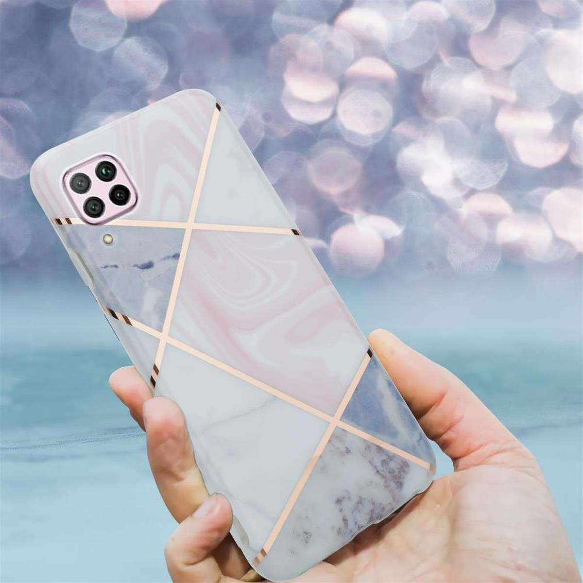 Una mano che tiene un telefono con una custodia a motivo marmorizzato bianco e linee geometriche dorate, con più fotocamere.
