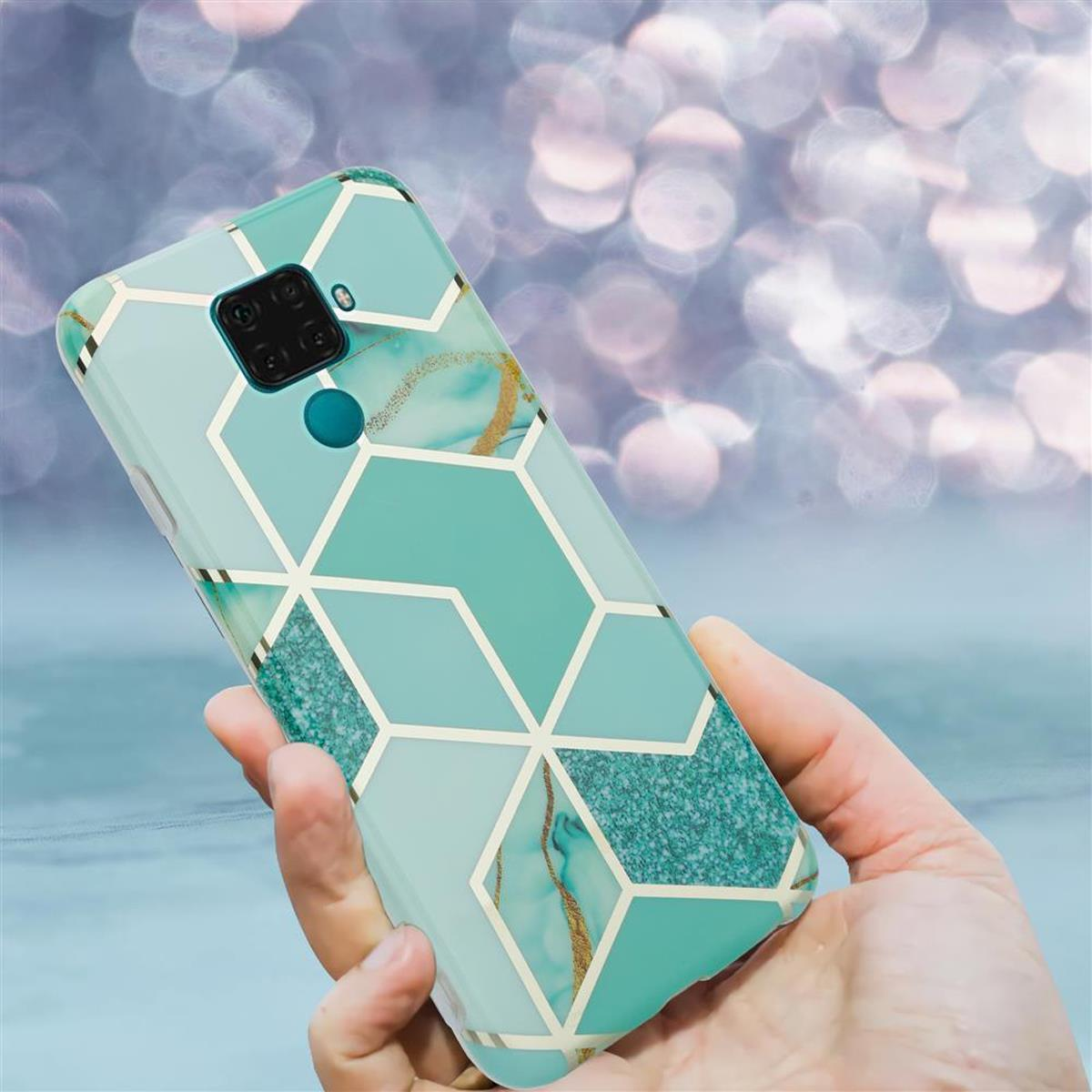 Mano che tiene una custodia per telefono con un design geometrico turchese e oro. Lo sfondo è sfocato.