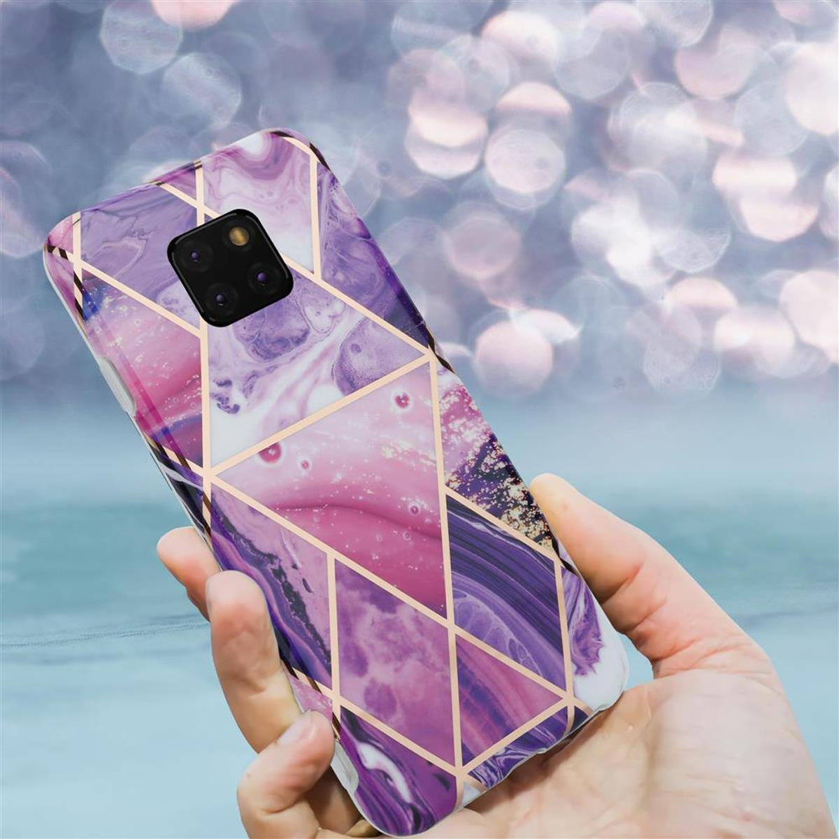 Una custodia per telefono con un design marmoreo e accenti dorati viene tenuta in mano. La fotocamera del telefono è visibile. Lo sfondo è sfocato.
