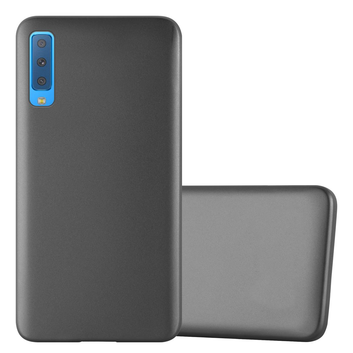Graue Handyhülle neben einem Telefon. Die Handyhülle ist glatt.