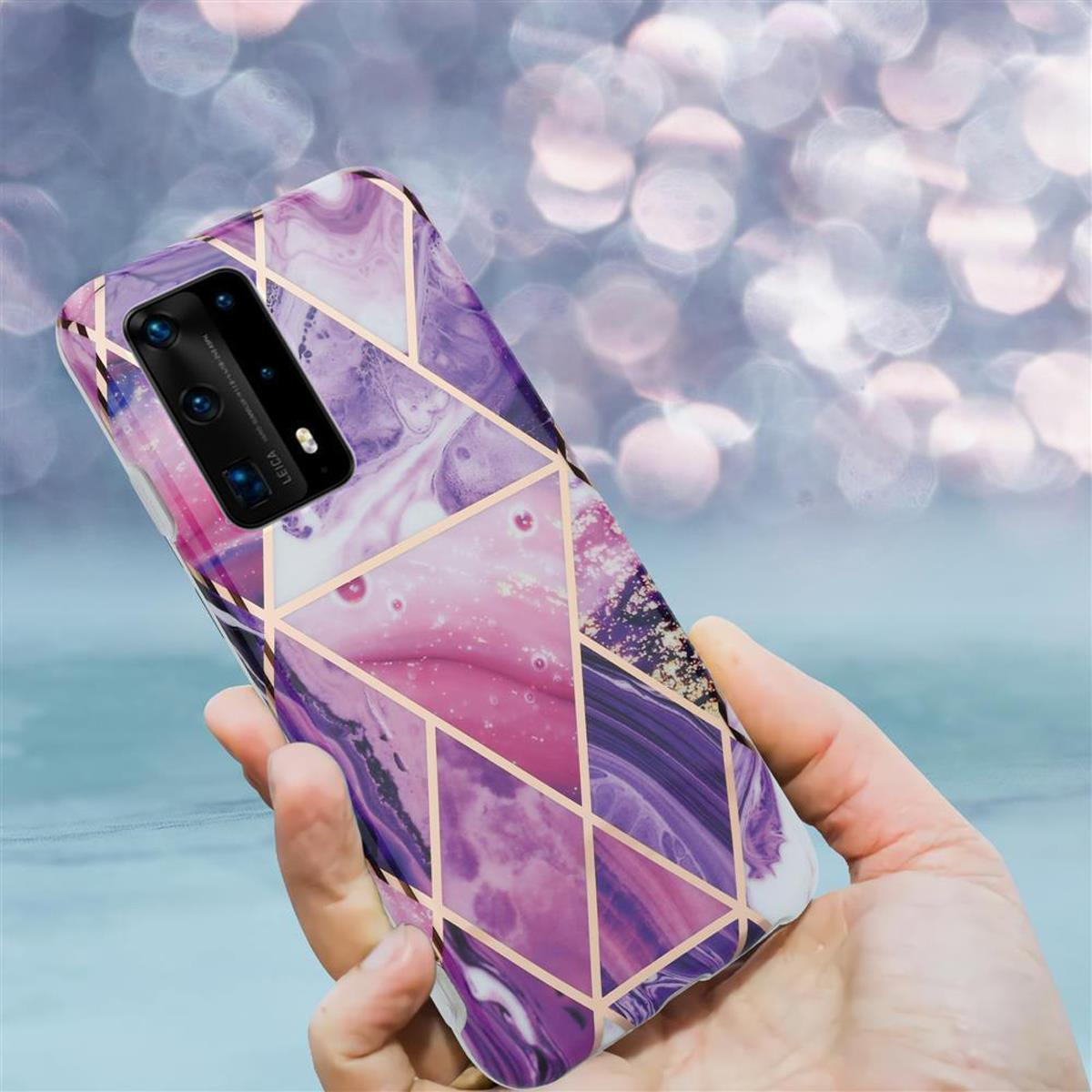 Mano che tiene un telefono con custodia dal design marmorizzato. Accenti dorati, toni viola e rosa.