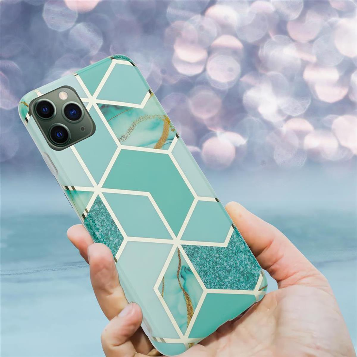 Una mano tiene una custodia per telefono con un design geometrico verde acqua con accenti dorati. Lo sfondo è sfocato.