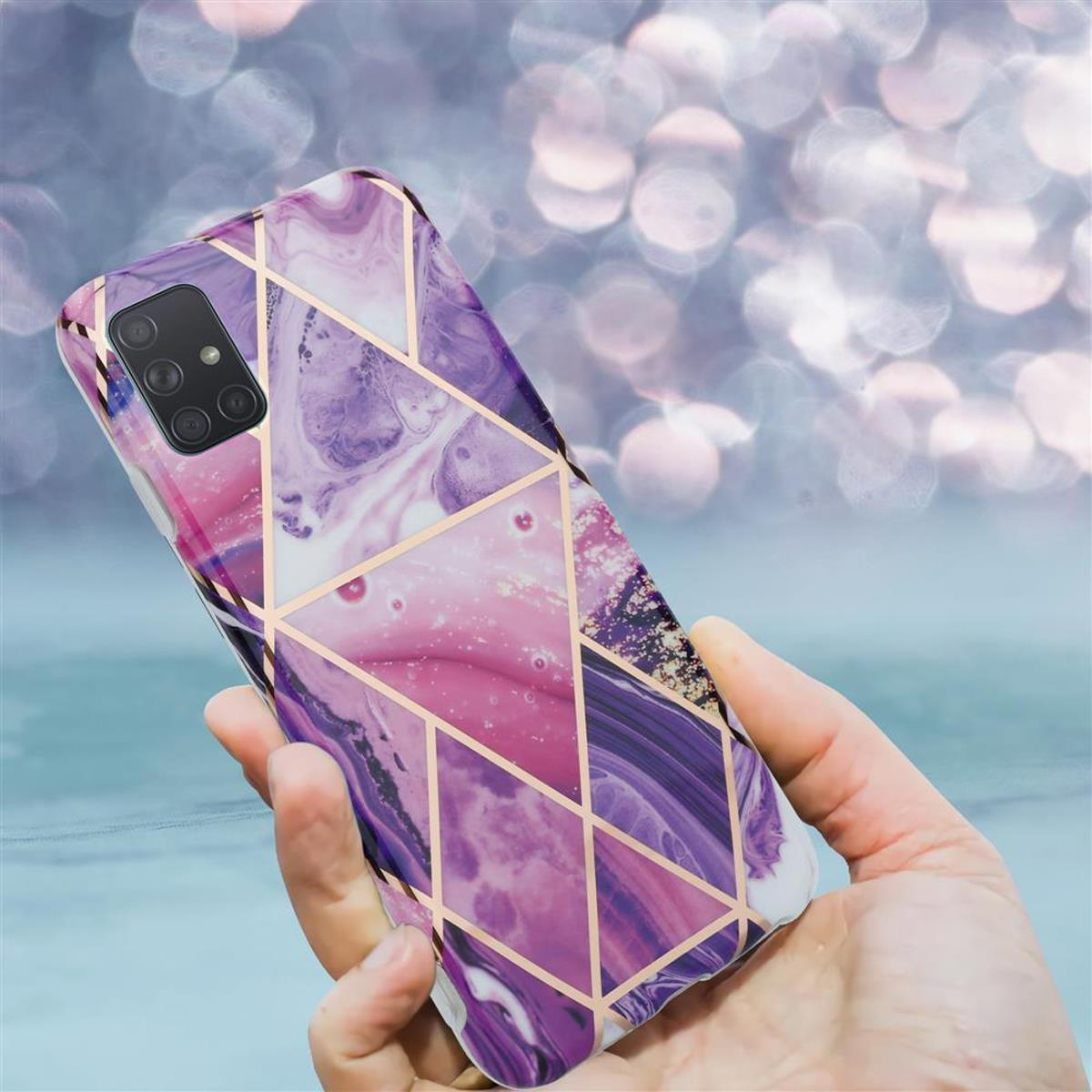 Una mano che tiene uno smartphone con una custodia a fantasia. La custodia ha un design geometrico viola e oro.