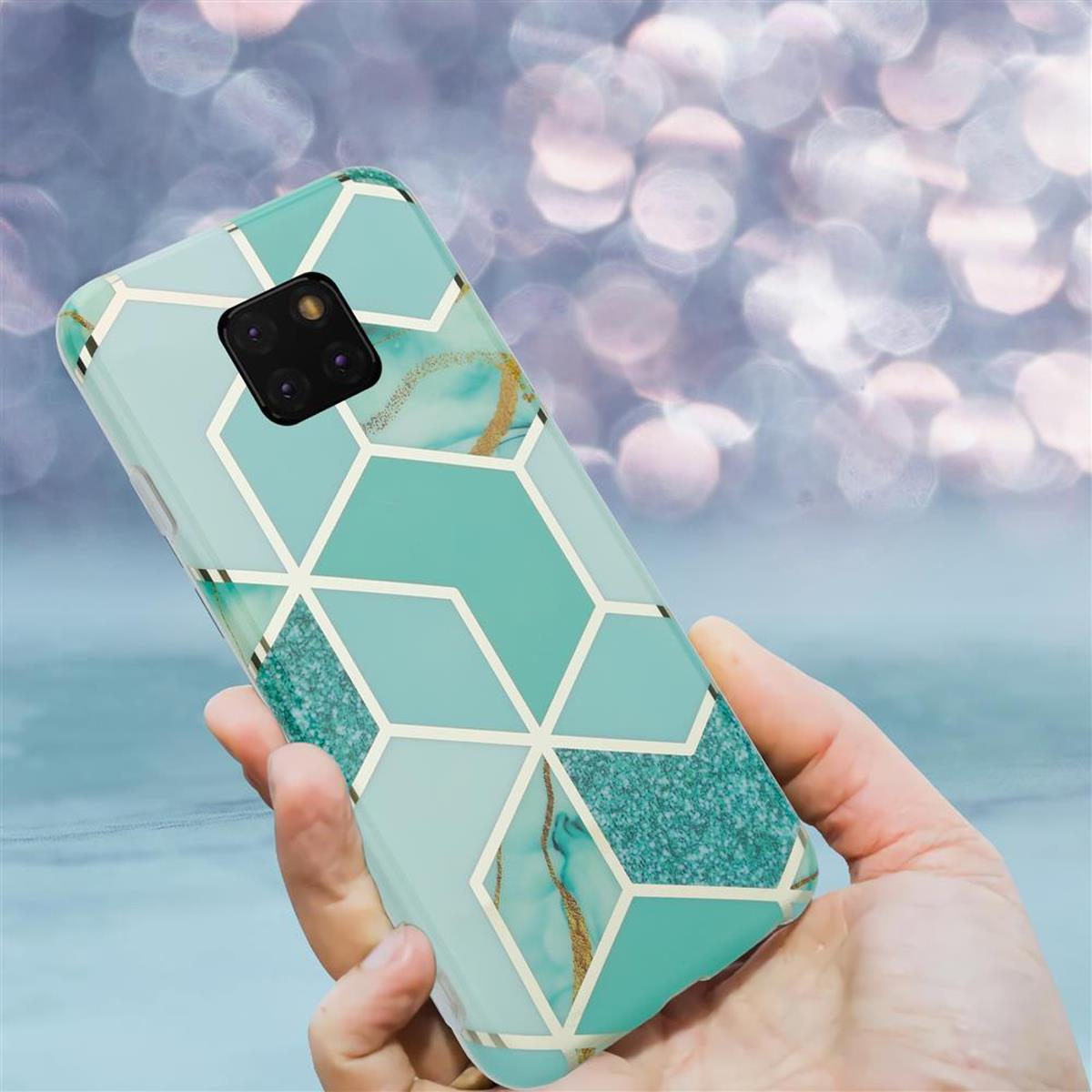 Una mano tiene una custodia blu per telefono con motivi geometrici ed effetto marmo su sfondo bokeh.