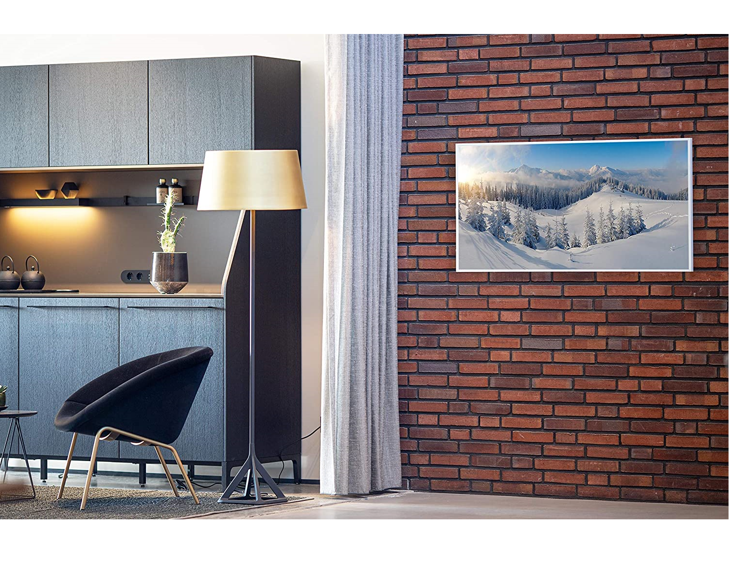 Ein modernes Interieur zeigt einen Fernseher mit einer verschneiten Berglandschaft, eine Stehlampe und einen schwarzen Stuhl.