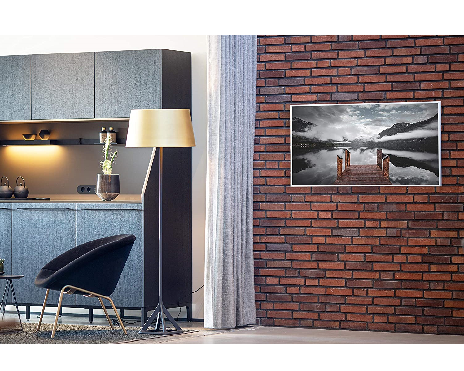 Ein modernes Interieur mit Backsteinmauer, Gemälde, schwarzem Stuhl und Stehleuchte mit goldenem Schirm.