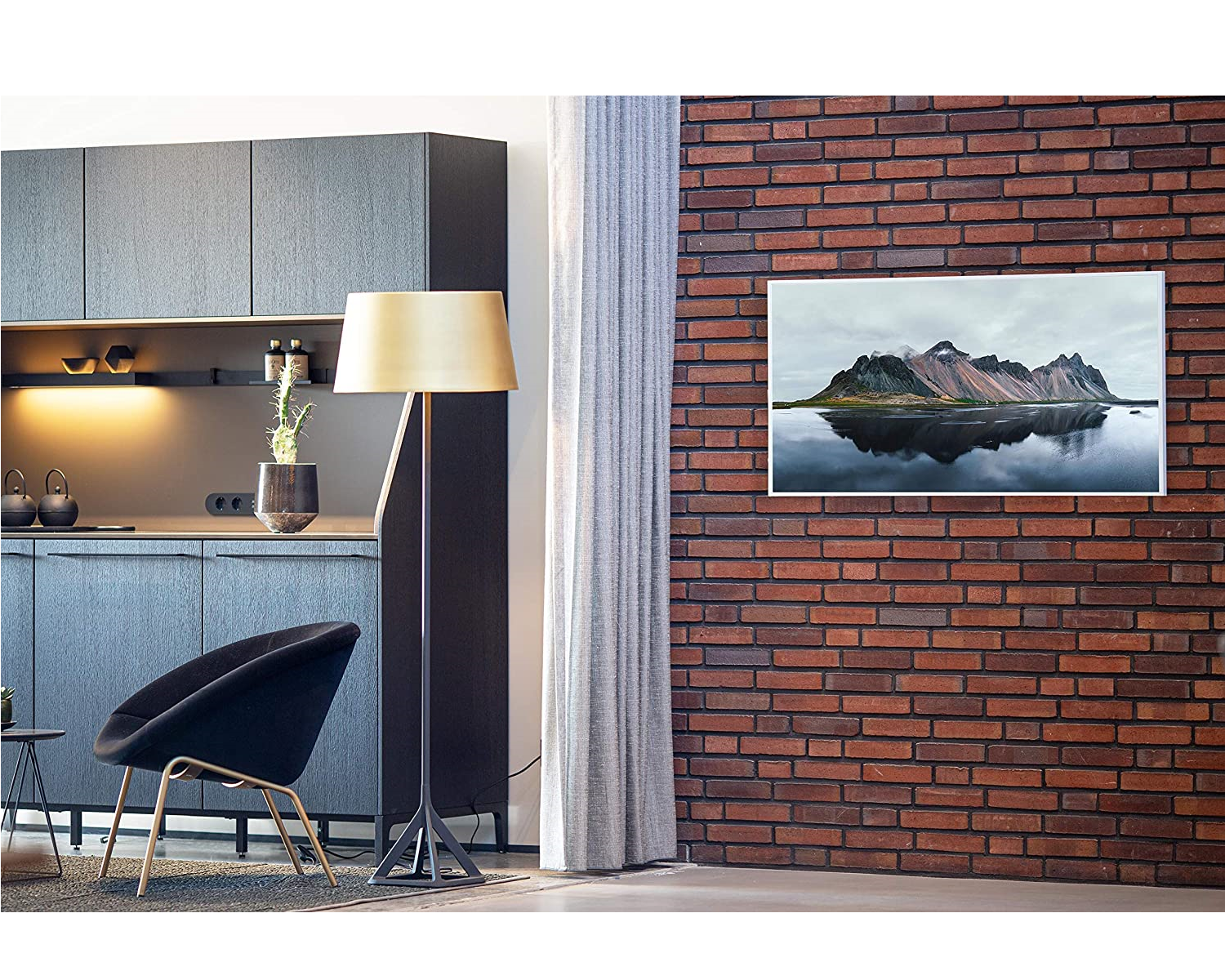 Ein modernes Wohnzimmer mit Backsteinmauer, Kunst, Stehlampe und schwarzem Stuhl.