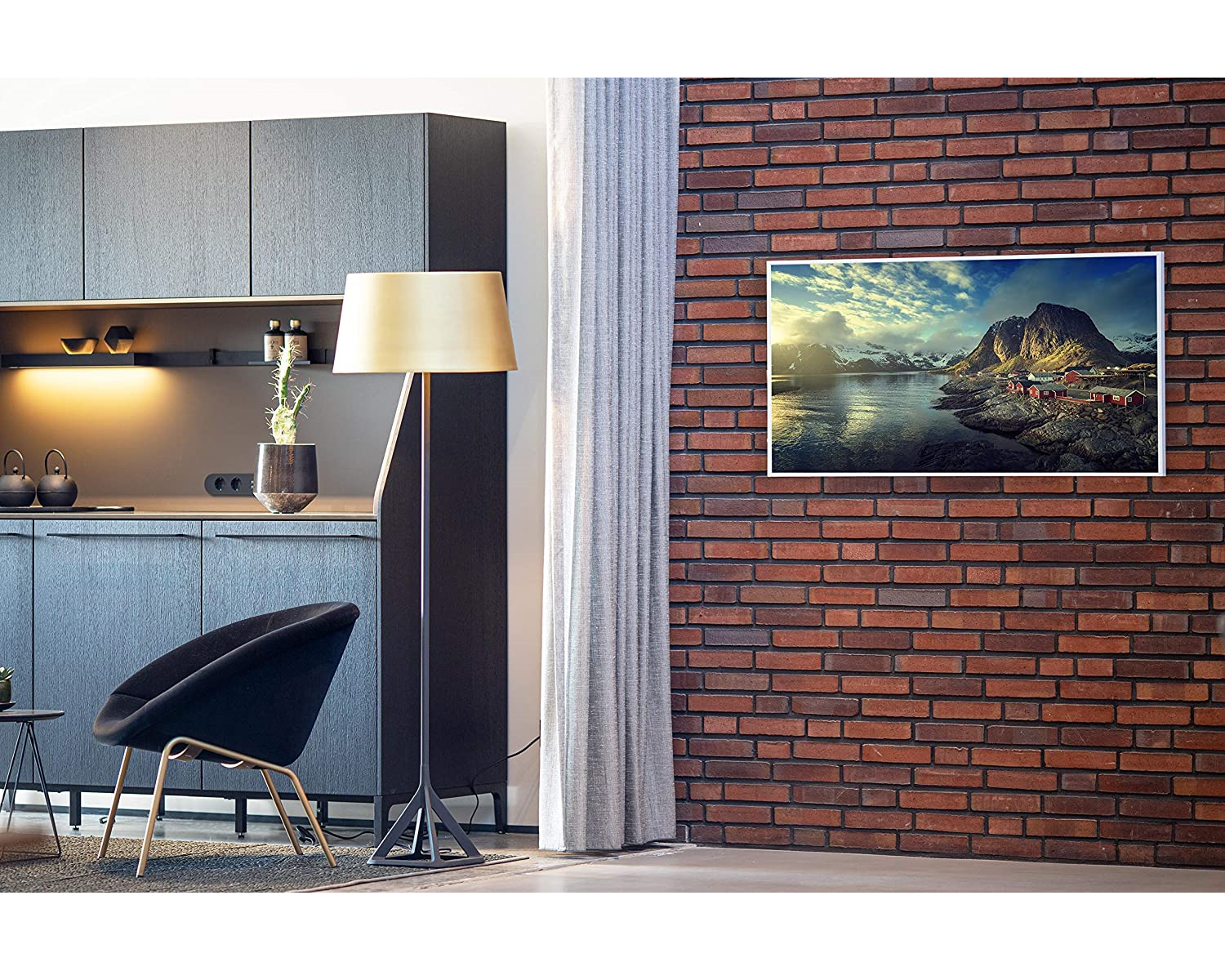 Zimmer mit schwarzem Stuhl, Lampe und Backsteinmauer mit einem Landschaftsbild.