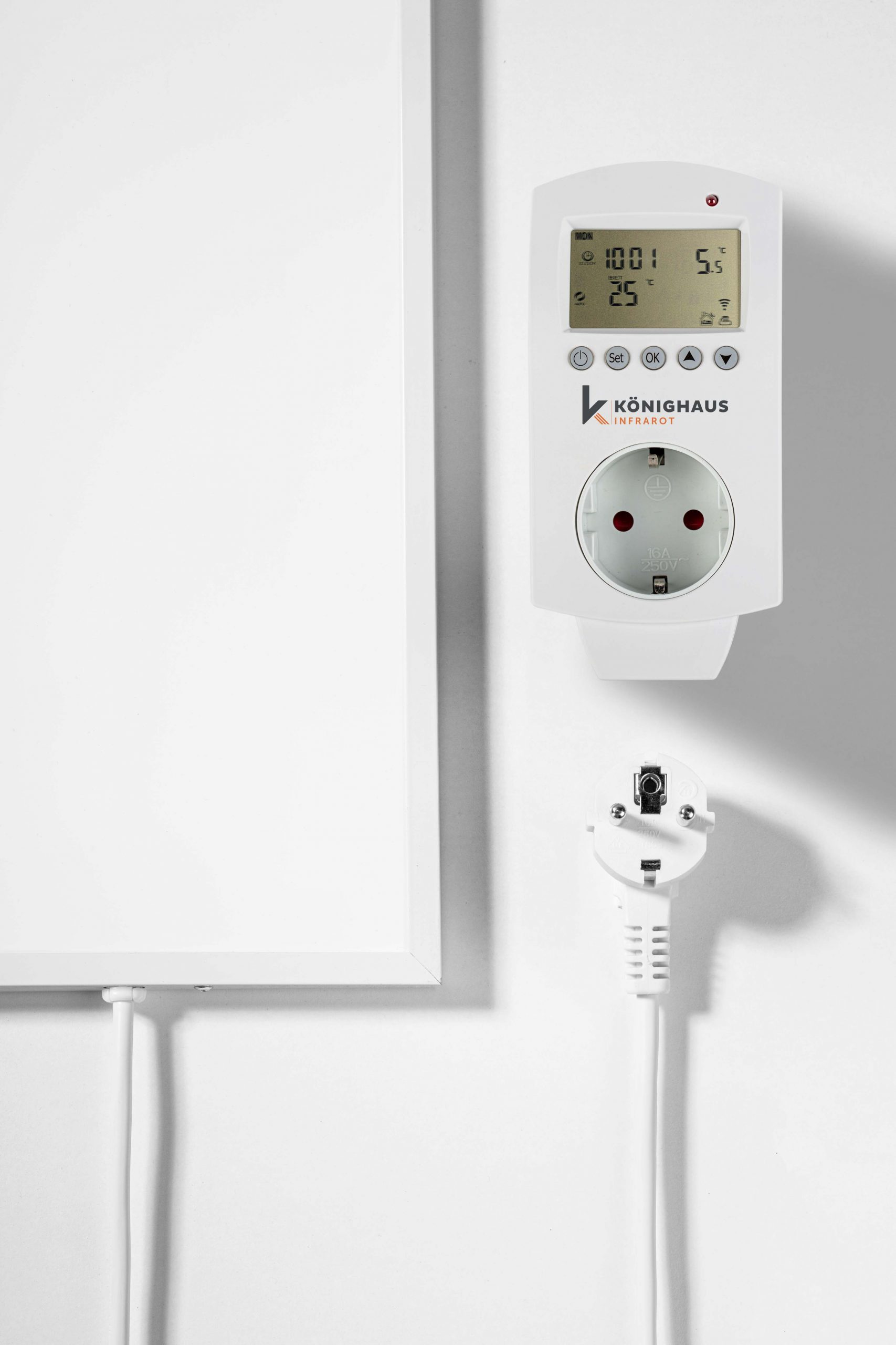 Weißer Infrarotheizungs-Thermostat und Steckdose. Weißer Stecker ist angeschlossen.