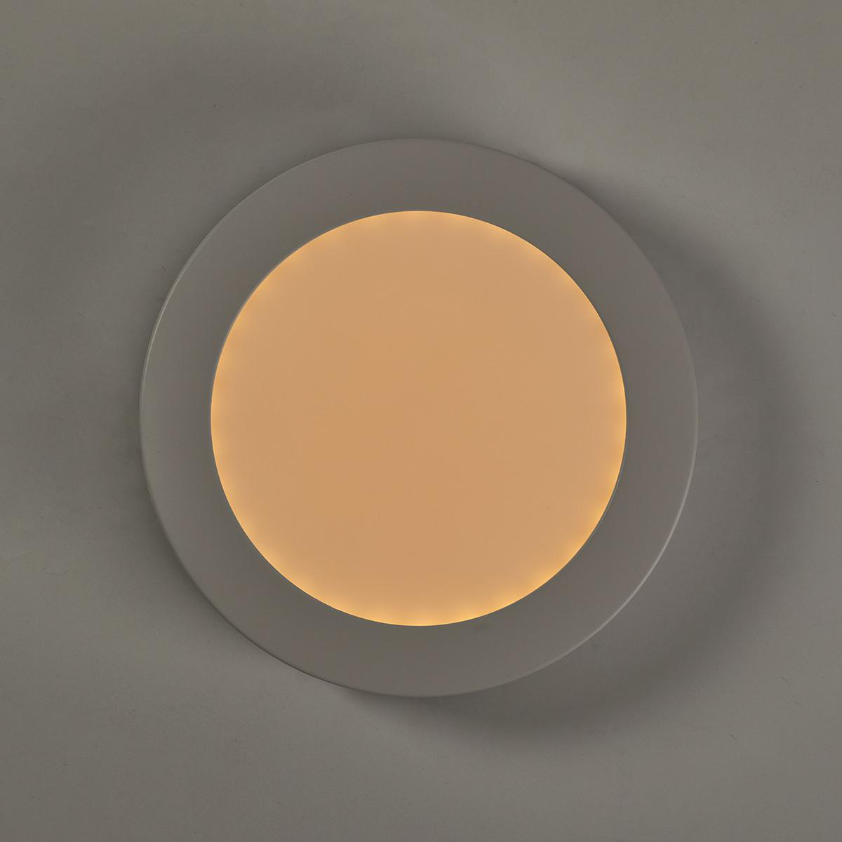 Plafoniera rotonda e bianca con una luce centrale giallo-arancio brillante.