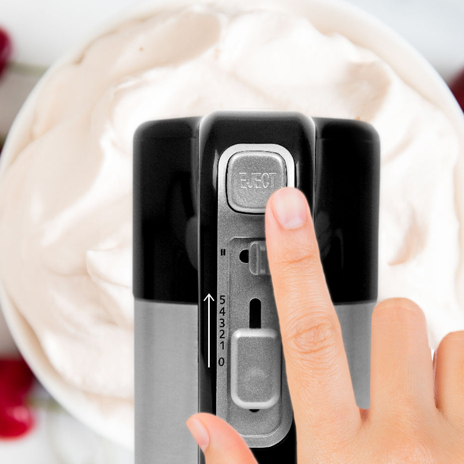 Hand bedient einen elektrischen Mixer mit Schlagsahne. Die 'EJECT'-Taste wird gedrückt.