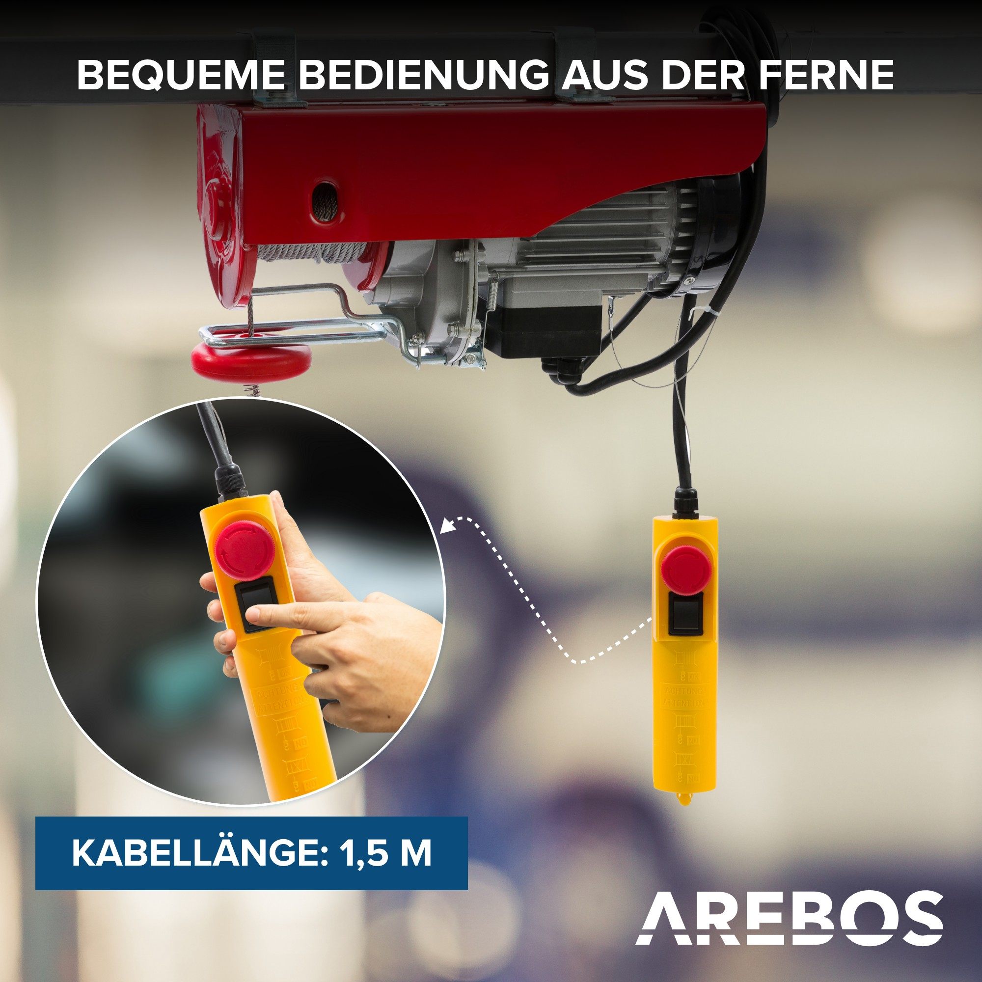 Ein roter und grauer Elektro-Hebezug mit Fernbedienung, mit einer Hand, die die Steuerung bedient.