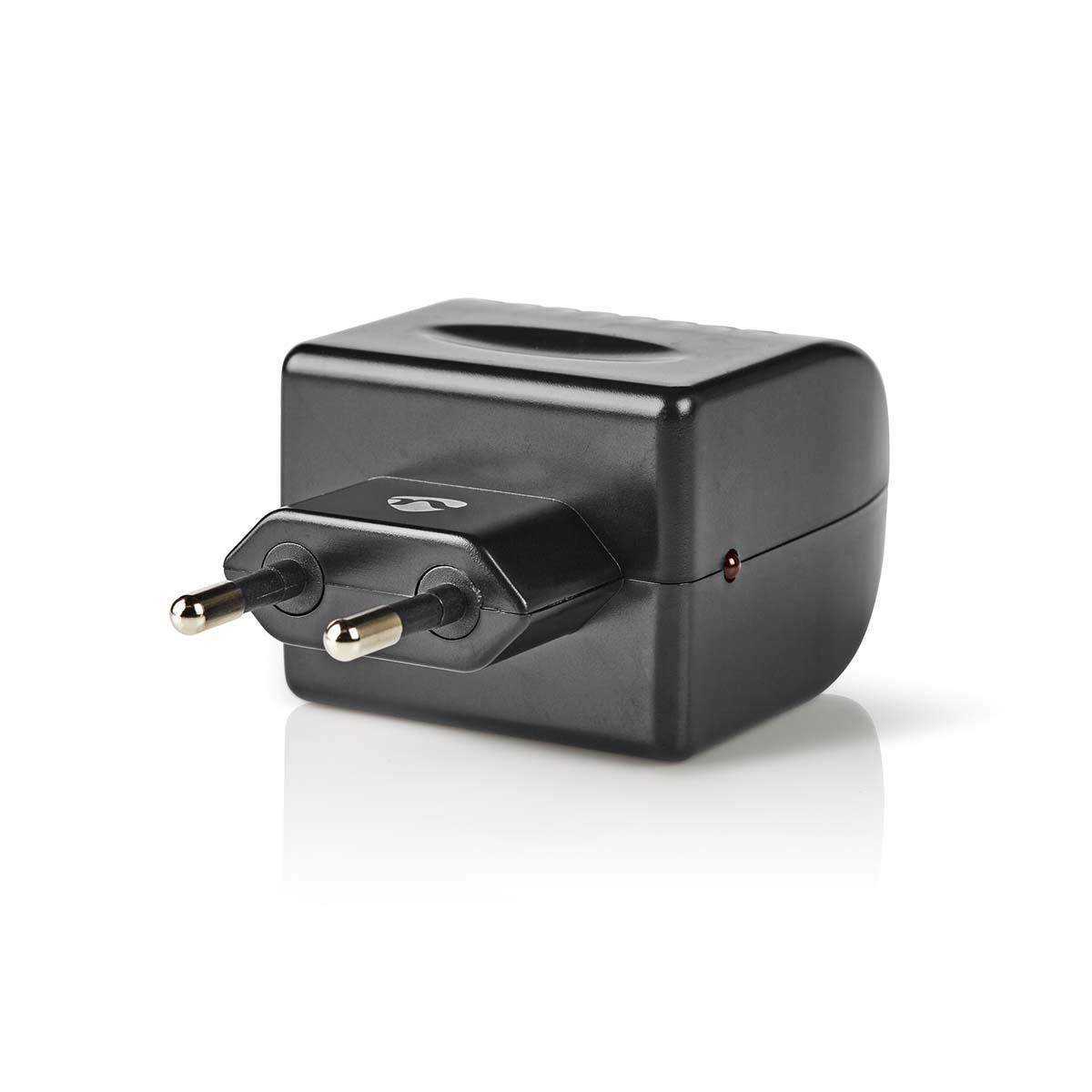 Schwarzer Adapter mit zwei Stiften, ein kleines rotes Licht. Auf weißem Hintergrund, mit Schatten.