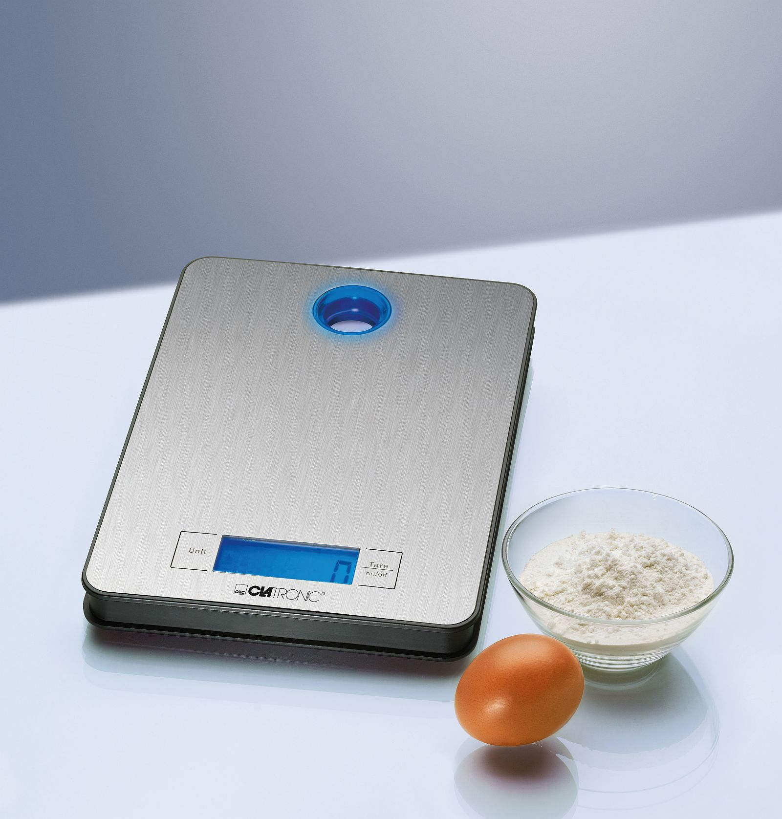 Waga kuchenna ze stali nierdzewnej z jajkiem i miską mąki obok.