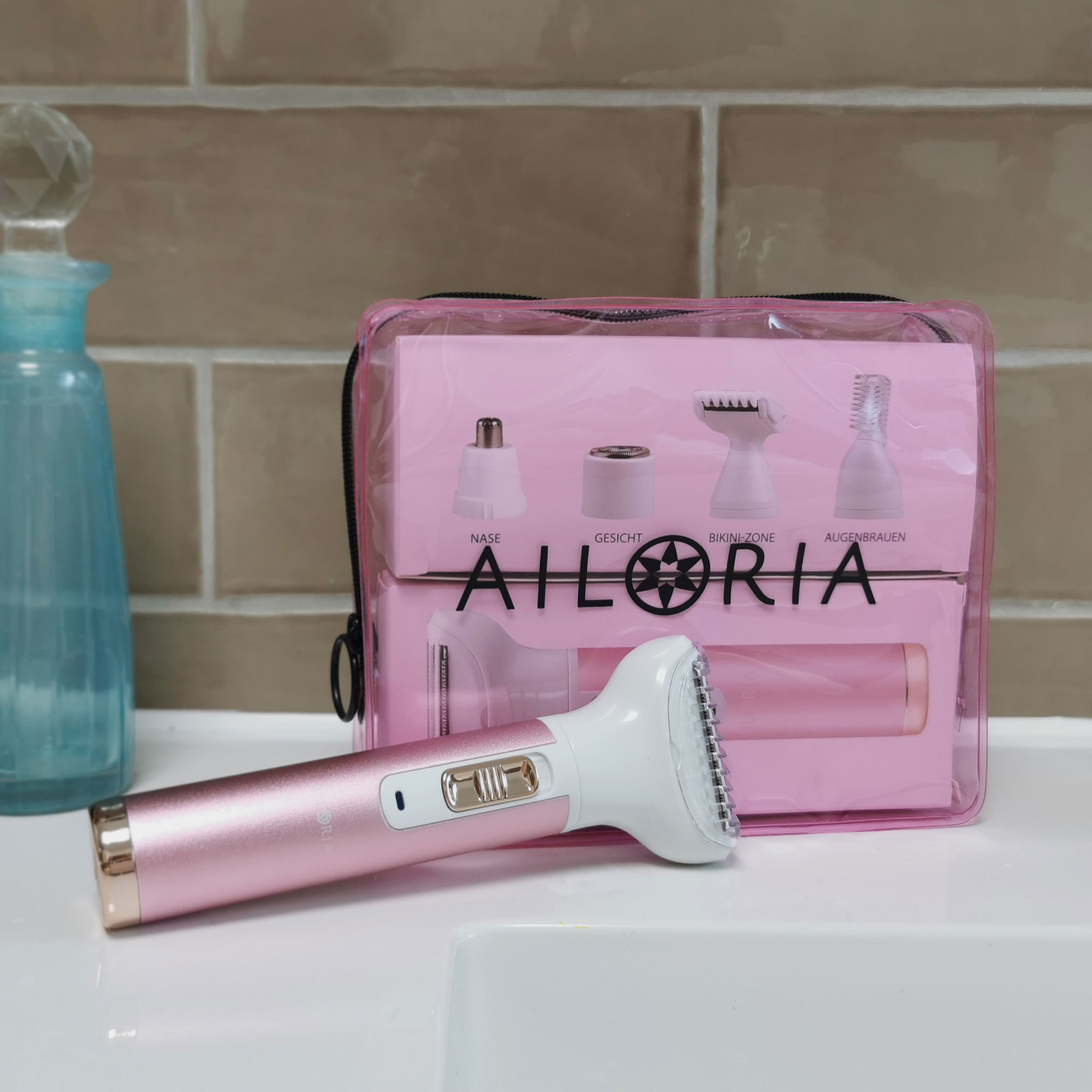 Un epilatore rosa e una borsa rosa trasparente con testine. È su una superficie bianca.