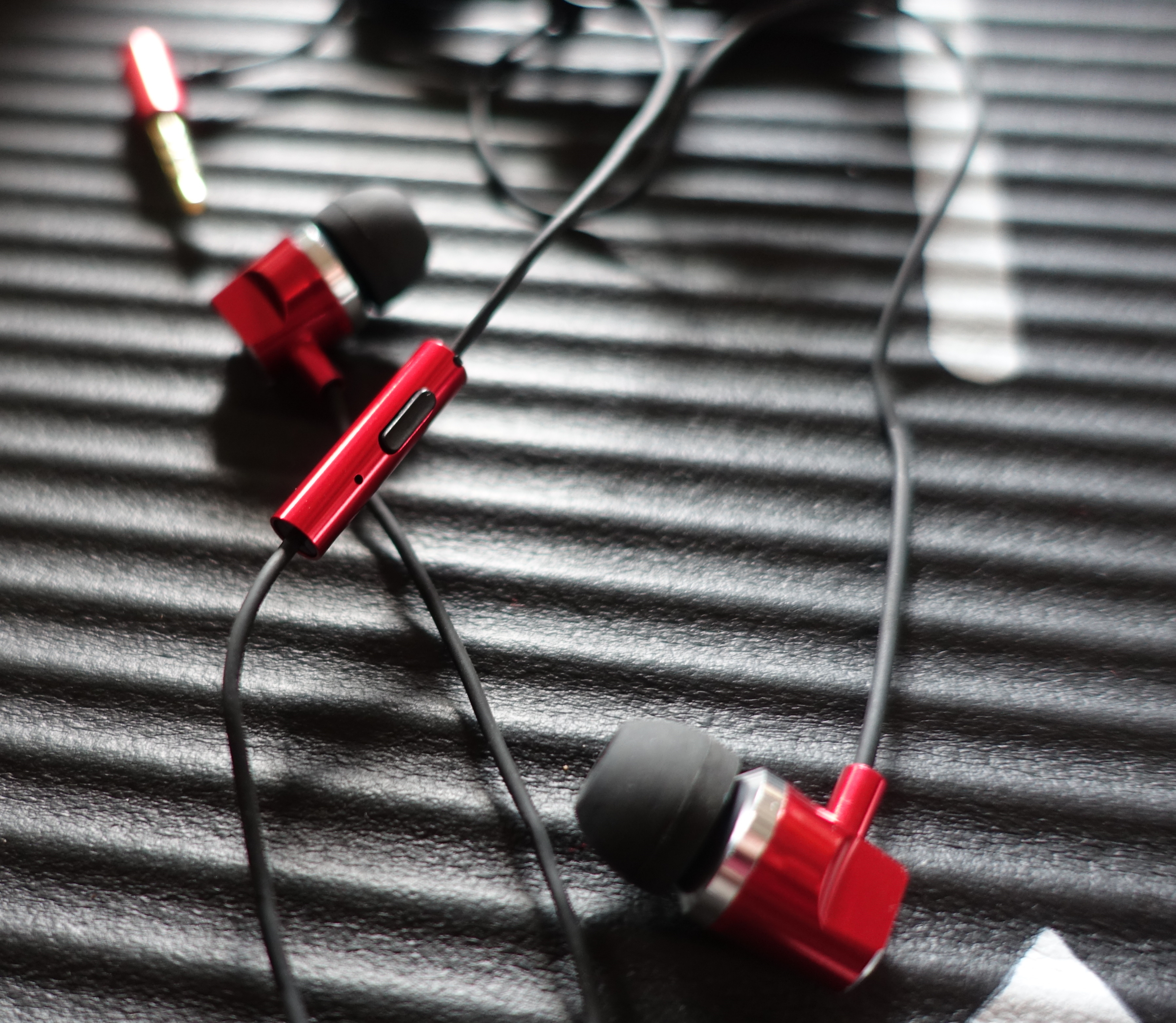 Roter Kopfhörer mit schwarzem Ohrhörer und Kabel.