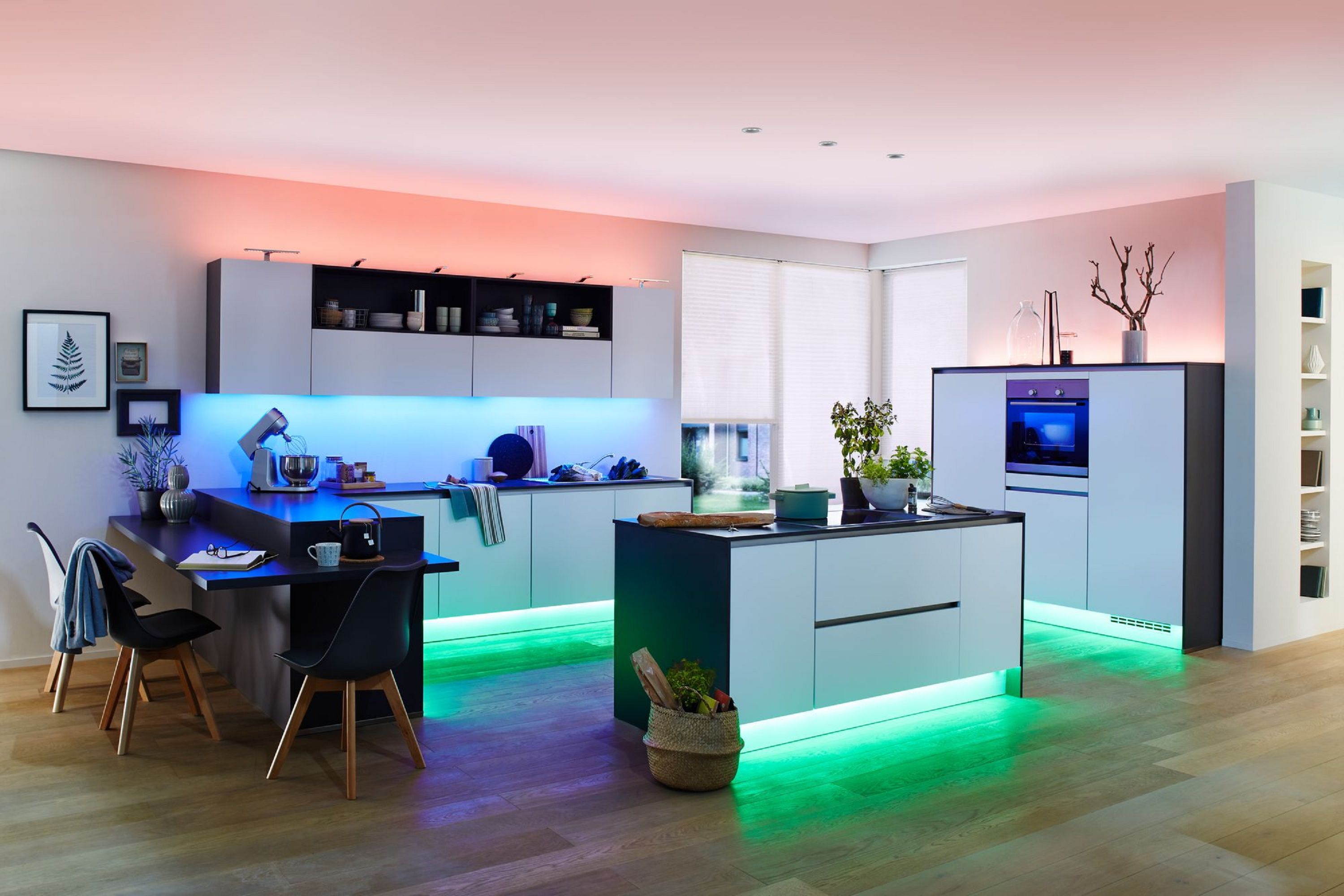 Eine moderne Küche mit blauer und grüner LED-Beleuchtung und einer Kücheninsel.