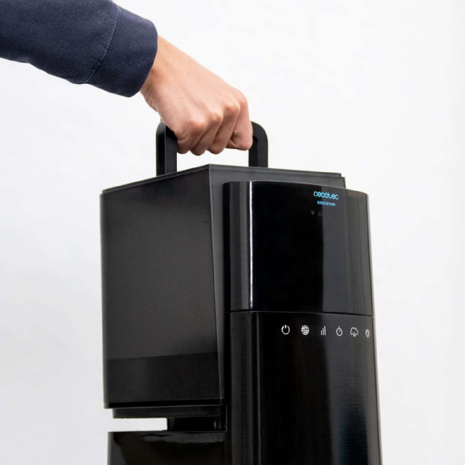 Una mano che tiene un refrigeratore d'aria a torre nero, su sfondo bianco.