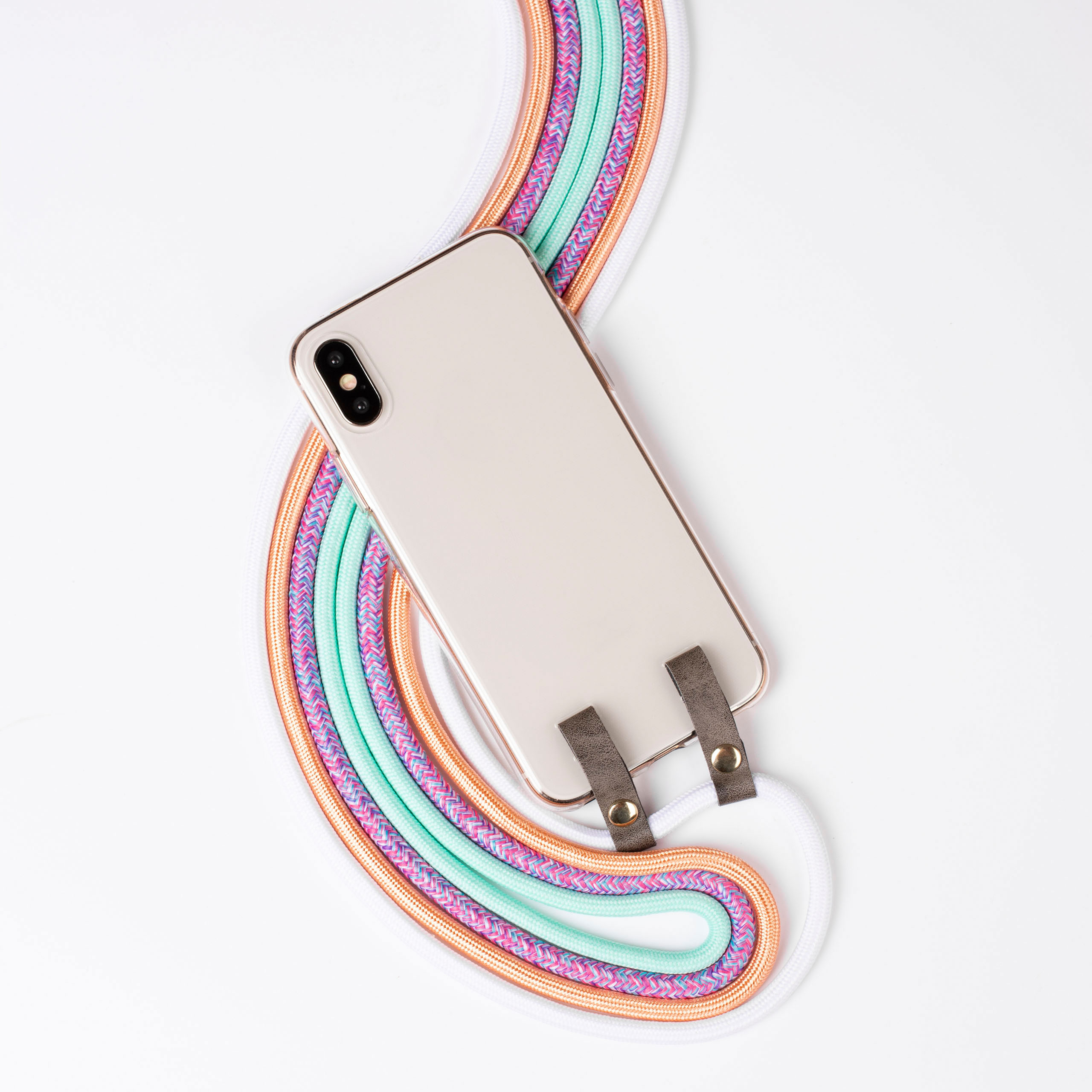 Smartphone mit einer regenbogenfarbenen Lanyard, braune Lederbefestigungen auf weißer Oberfläche.
