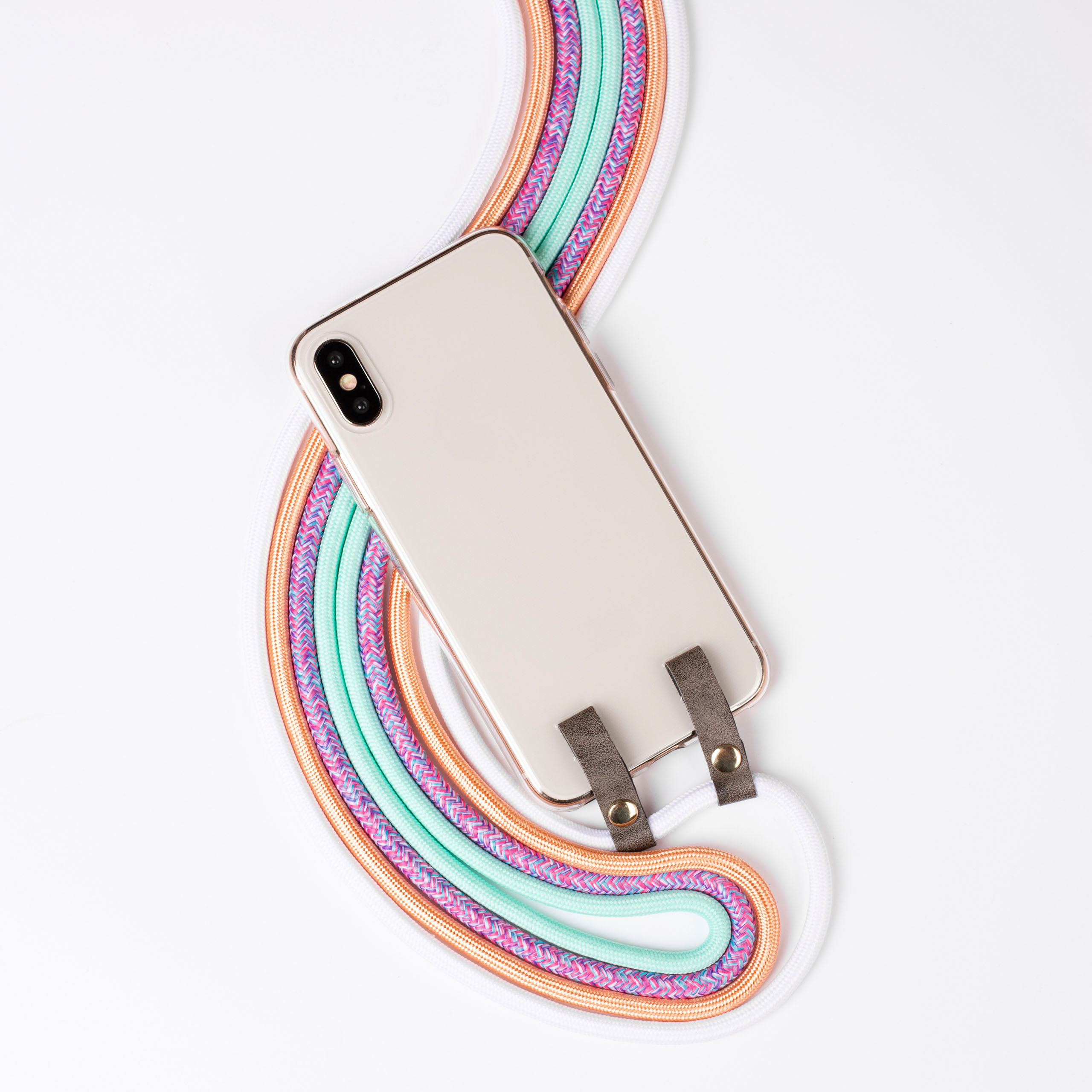 Ein Telefon mit goldenem Rahmen ist mit einem mehrfarbigen Riemen verbunden.