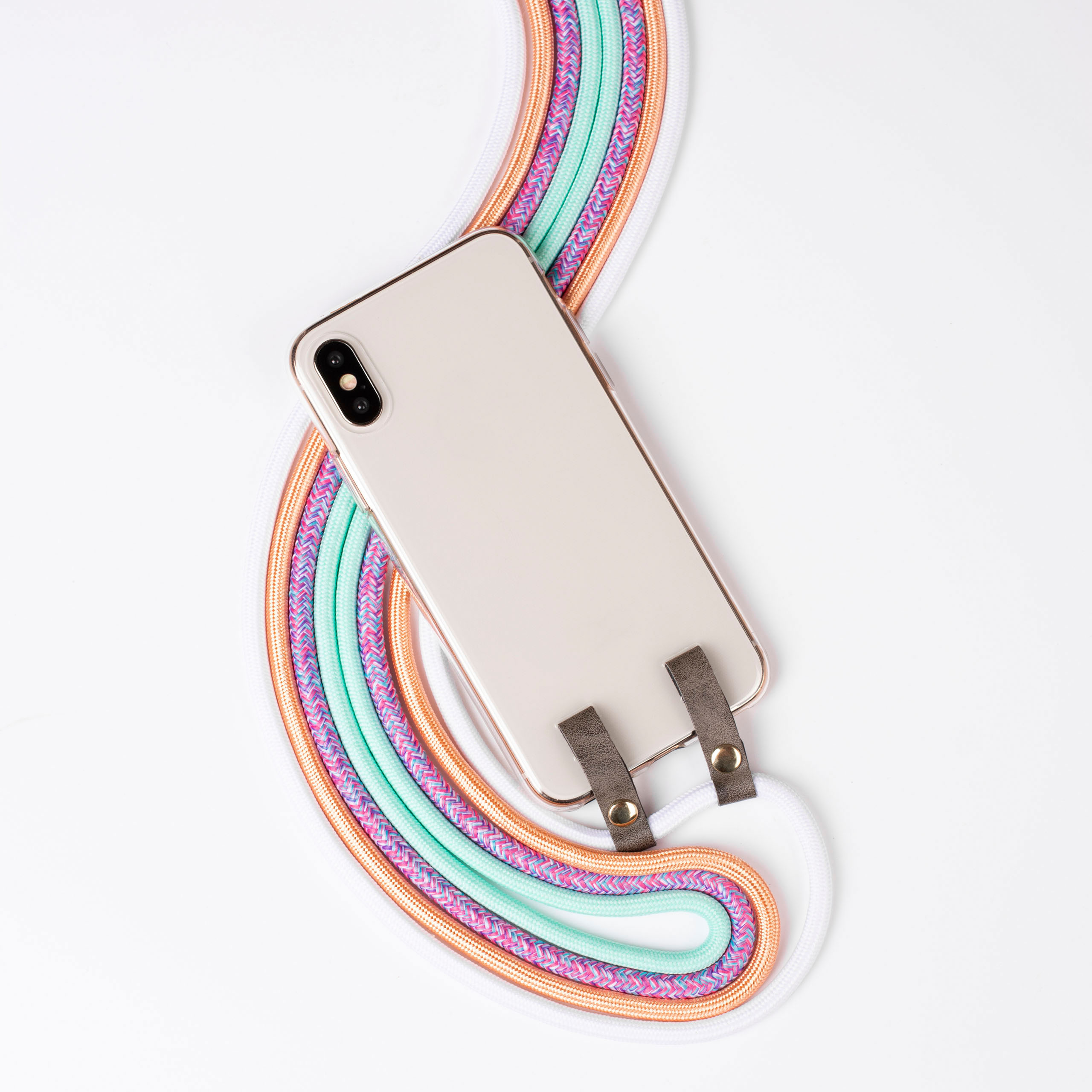 Ein Telefon mit weißer Rückseite und bunten Kordeln. Das Telefon ist an grauen Lederriemen befestigt.