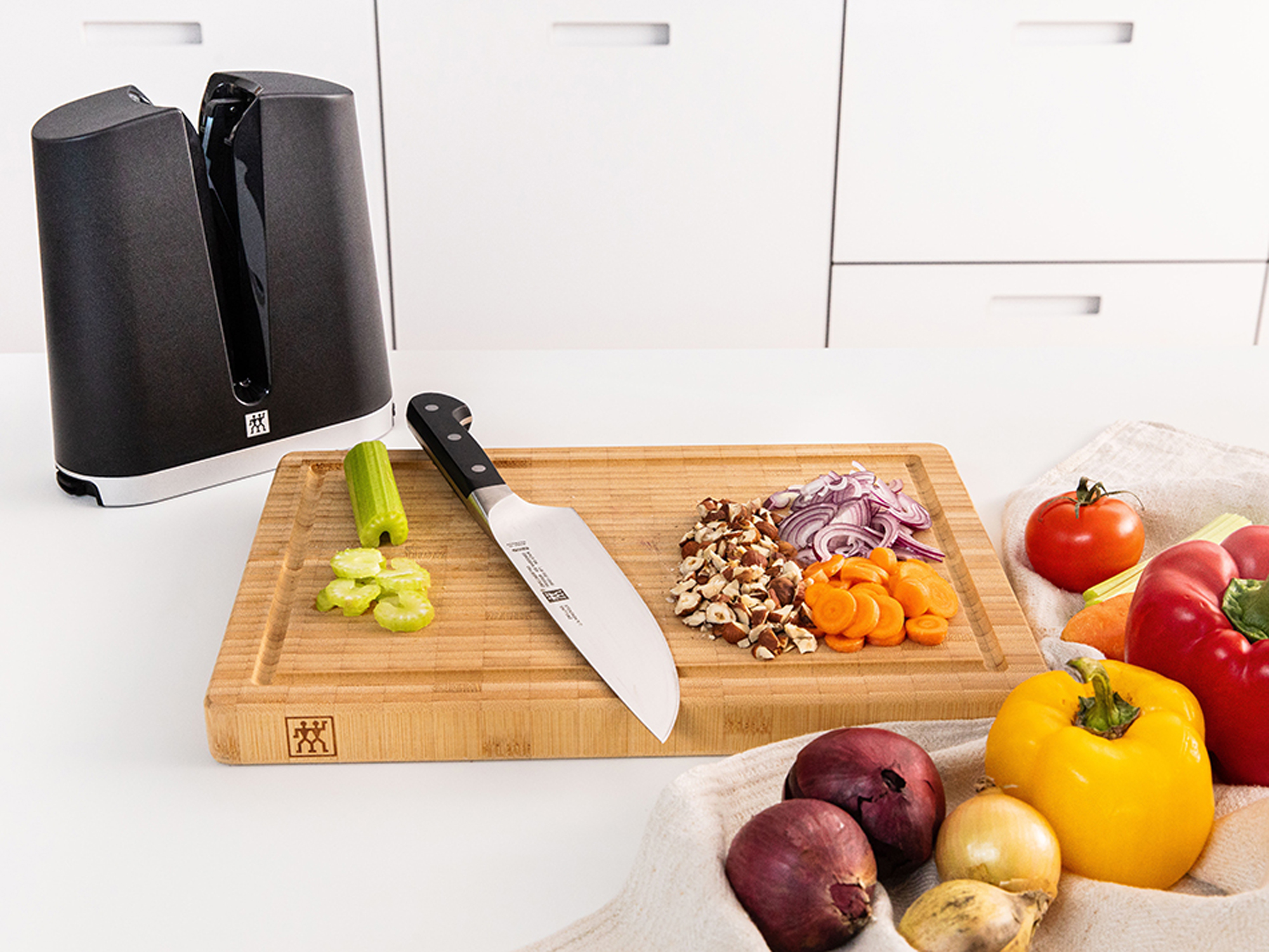 Nóż i jedzenie na drewnianej desce do krojenia z ostrzałką w tle.