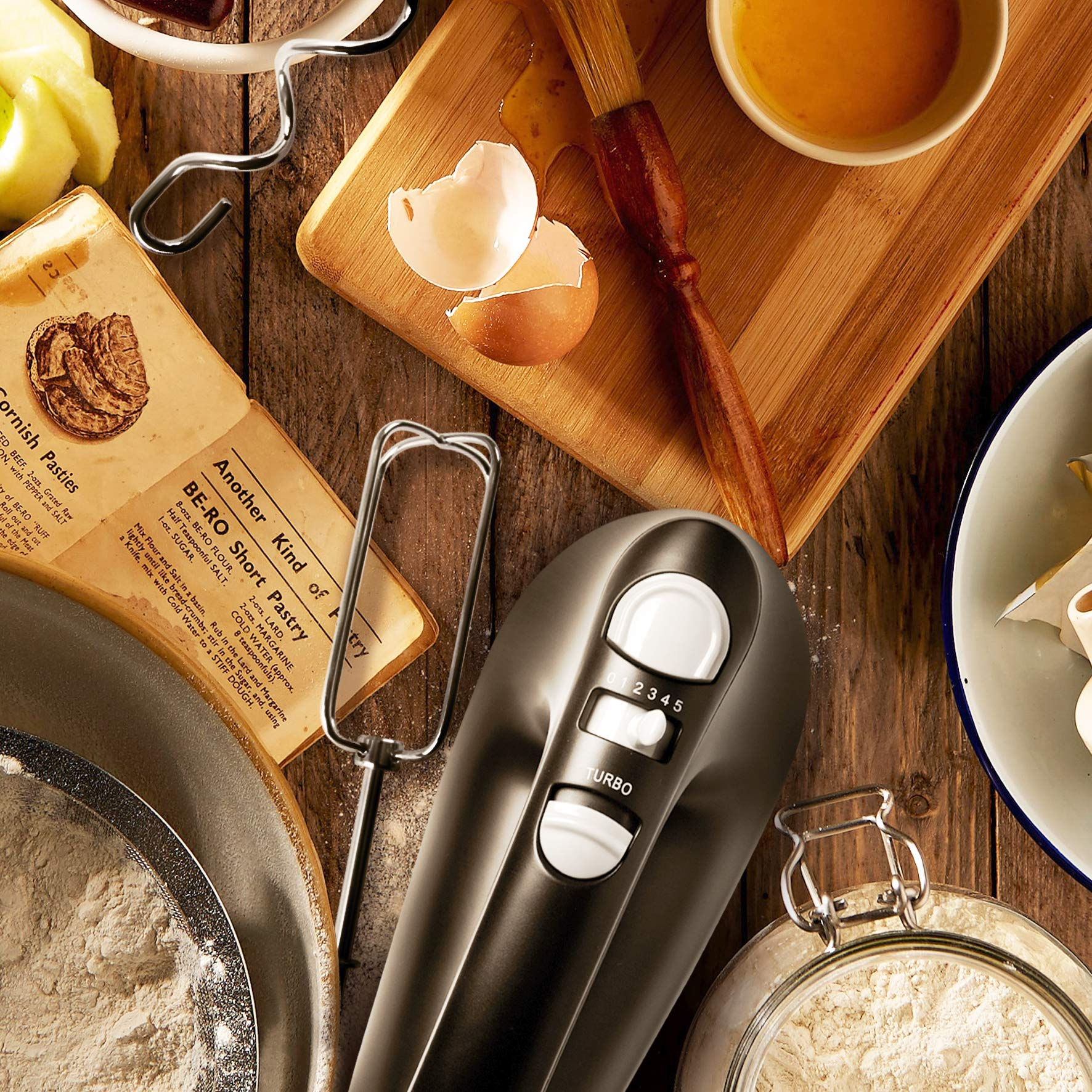 Batidora de mano, ingredientes y utensilios de repostería sobre superficie de madera. Harina, huevos, brocha.