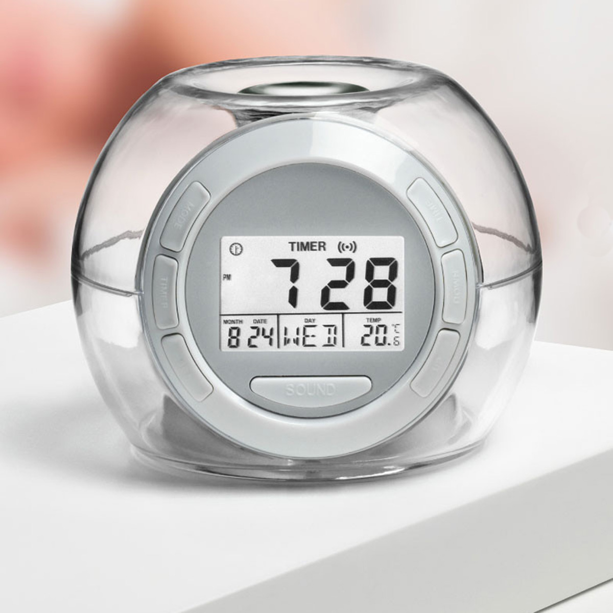 Reloj despertador esférico transparente con pantalla digital que muestra la hora, fecha y temperatura. Botones.