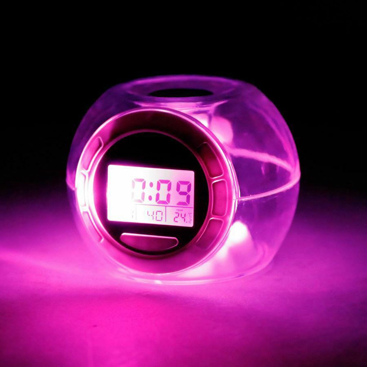 Un despertador esférico transparente brillando en rosa, con una pantalla digital mostrando la hora.