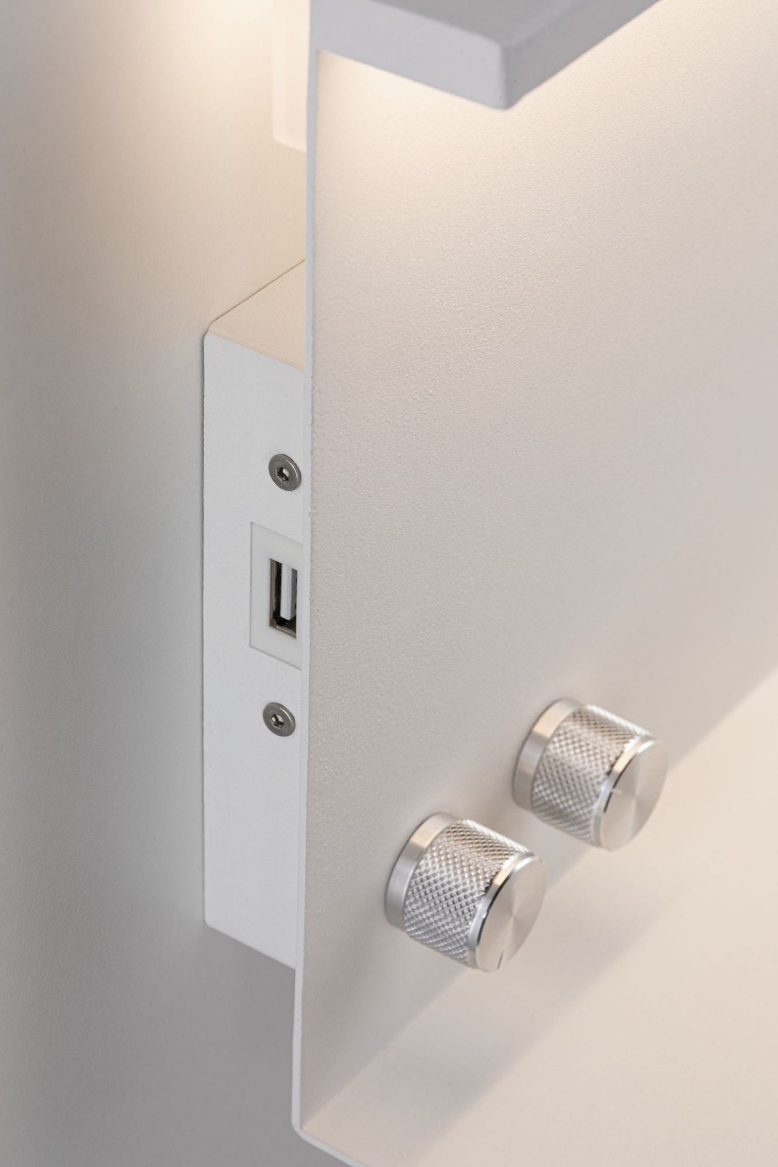 Wandleuchte mit USB-Anschluss und zwei Metallknöpfen.