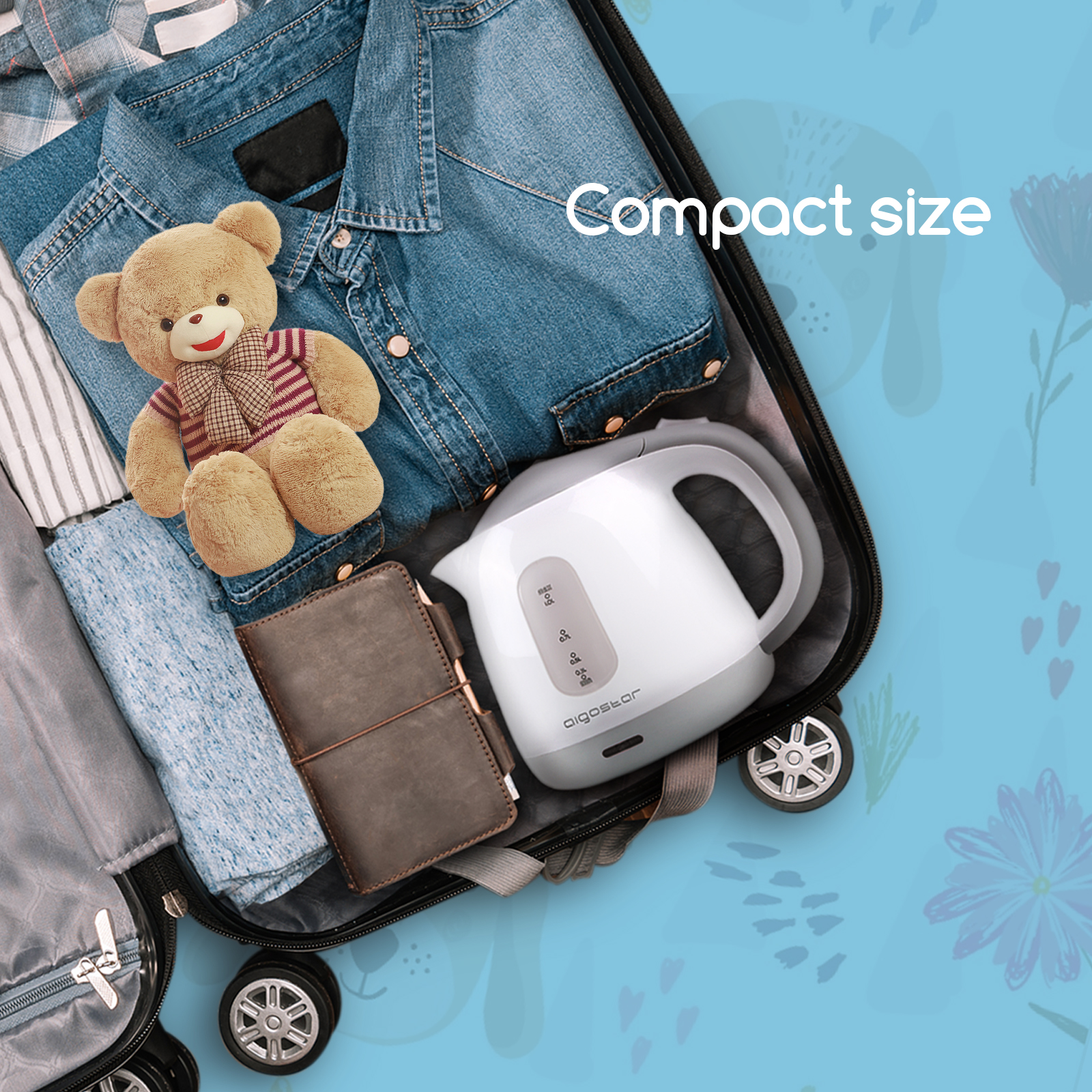 Koffer mit Kleidung, Teddybär und weißem Wasserkocher gepackt.