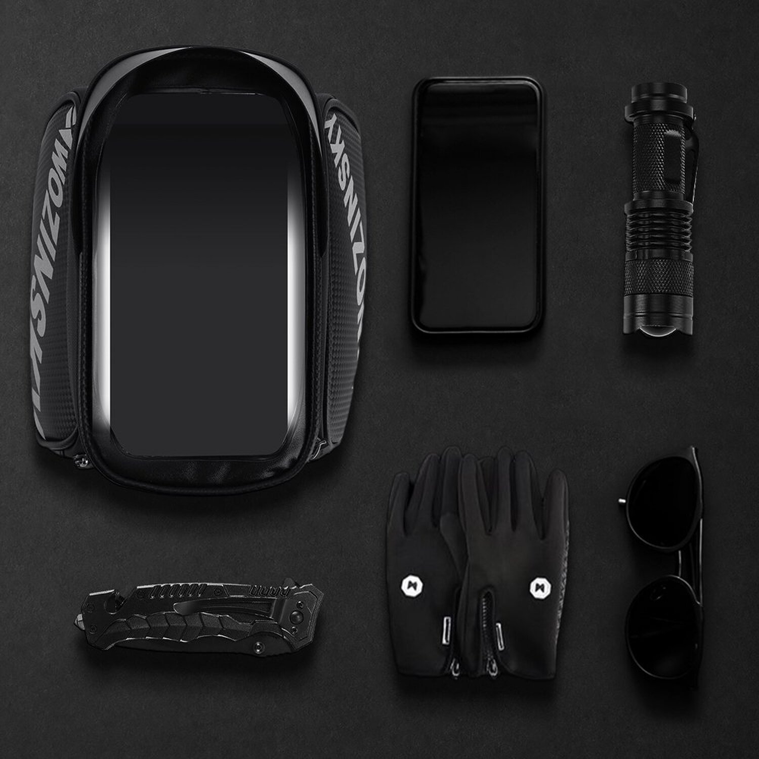 Schwarze Gegenstände auf schwarzem Untergrund: Tasche, Telefon, Handschuhe, Messer, Sonnenbrille und Taschenlampe.